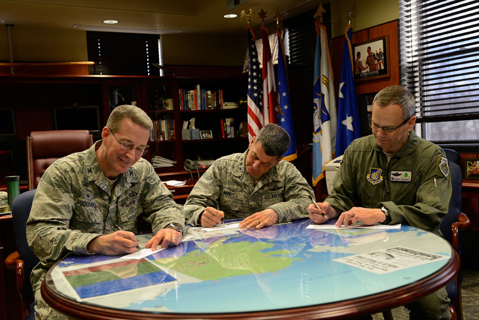 (From left to right) Air Force Col. Brian Bruckbauer, Joint Base Elmendorf-Richardson and 673d Air Base Wing commander; Air Force Lt. Gen. Russell Handy, Alaskan Command, 11th Air Force and Alaskan North American Aerospace Defense Region commander; and Air Force Col. Charles Corcoran, 3rd Wing commander, sign Air Force Assistance Fund donation forms at Joint Base Elmendorf-Richardson March 10, 2016. The money collected by the campaign will fund four Air Force affiliated charities: the Air Force Villages Foundation, the Air Force Aid Society, the General and Mrs. Curtis E. LeMay Foundation and the Air Force Enlisted Village. (U.S. Air Force photo by Airman Valerie Monroy)