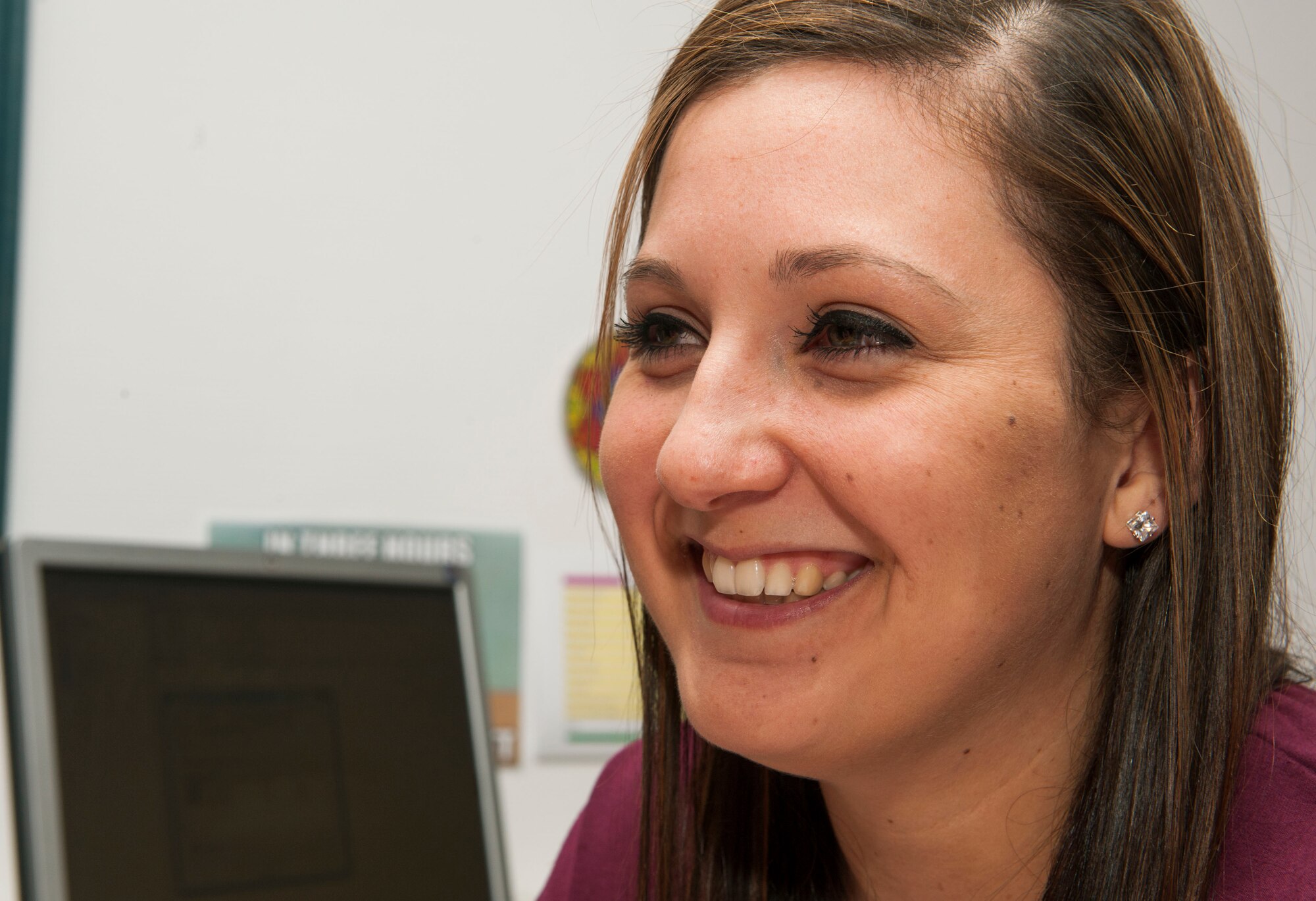 Mariah Johnson, a 52nd Force Support Squadron value-added tax officer and Spangdahlem Brazilian Jiu Jitsu class member, smiles while talking with a coworker in the VAT office at Spangdahlem Air Base, Germany, March 8, 2016. Johnson stated she attends Jiu Jitsu as a way to stay physically and mentally fit. (U.S. Air Force photo by Airman 1st Class Timothy Kim/Released)