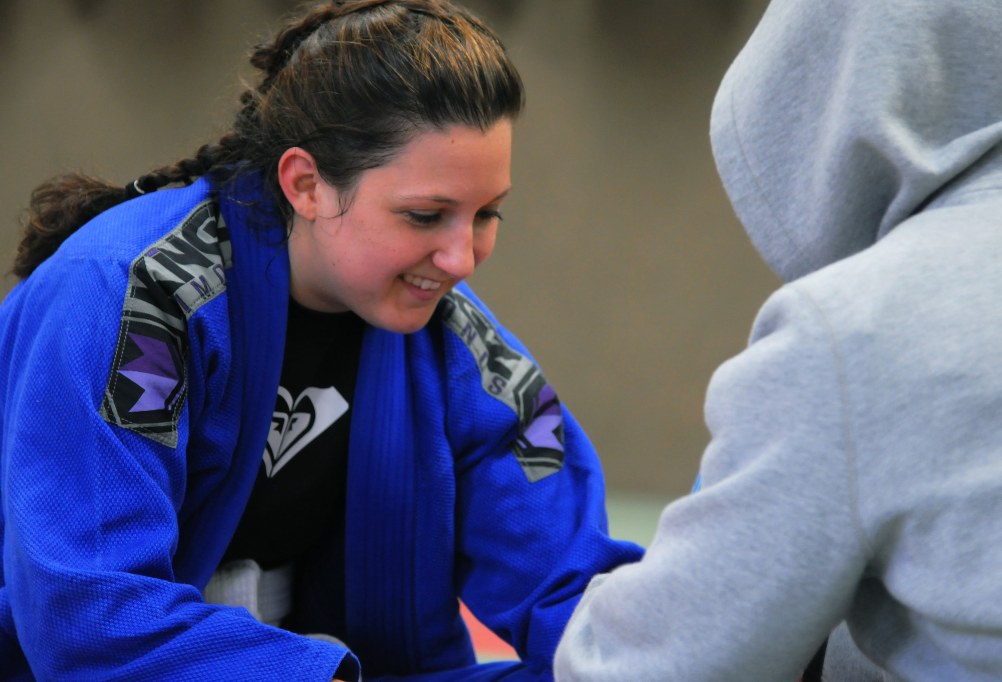 Mariah Johnson, a 52nd Force Support Squadron value-added tax officer and Spangdahlem Brazilian Jiu Jitsu class member, left, smiles while her coach wraps her hands before her first match at the Submissao competition in Karlsruhe, Germany, Feb. 20, 2016. Johnson lost seven pounds to make the weight class for her match and trained with fellow martial artists. (Courtesy photo)