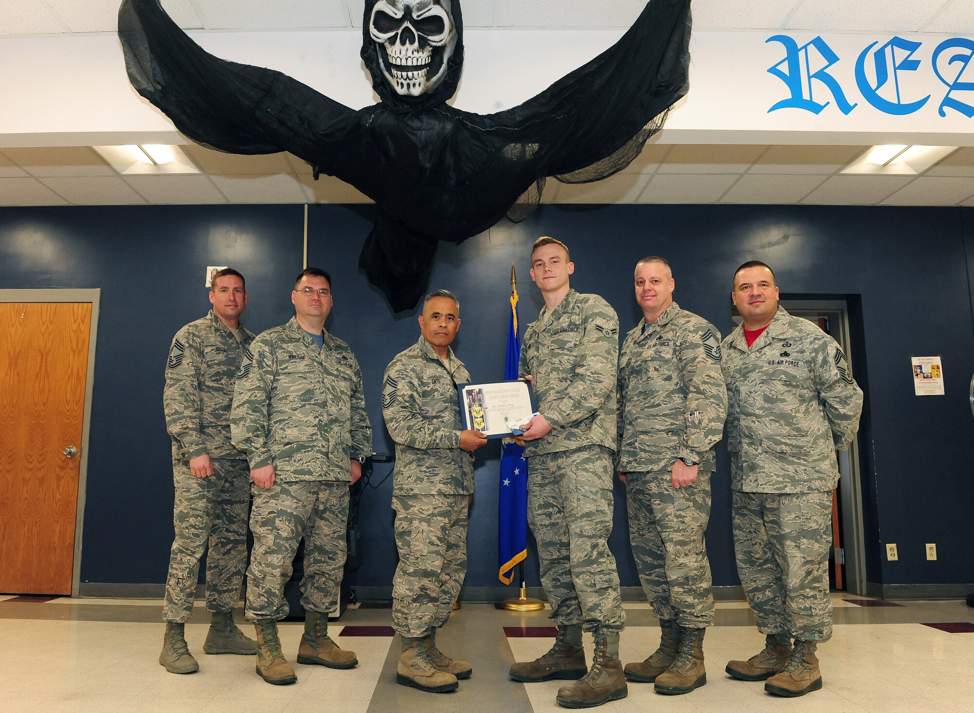 U.S. Air Force Airman 1st Class Austin King, an instrument and flight control systems journeyman assigned to the 509th Aircraft Maintenance Squadron, receives a Chief’s Choice award at Whiteman Air Force Base, Mo., March 11, 2016. During the first ever, no-notice operational readiness exercise at Whiteman, King helped repair a landing gear conduit by replacing a 50-pin connector, which led to generating aircraft 11 hours under the standard time for Air Force Global Strike Command. During the past year, he also volunteered over 100 hours through opportunities like collecting 1,000 pounds of trash and debris through the Adopt-A-Highway program and coordinating three fundraising events as the dorm council president. (U.S. Air Force photo by Airman 1st Class Jazmin Smith)