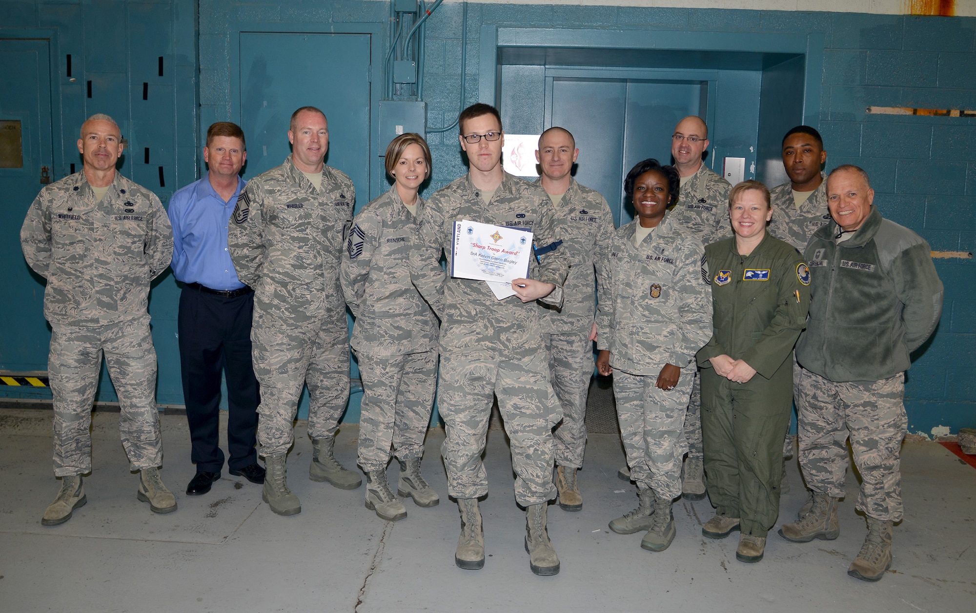 Members of the Chief's Group present Senior Airman Kelvin Glenn Bagley with the Sharp Troop Award. Bagley, who works in the 58 Aircraft Maintenance Squadron, was recognized for his professionalism as an Airman.  He was also selected for displaying great customer service at the Booster Club's gift-wrapping table at the Base Exchange in December, positively representing Kirtland and the Air Force.  (Photo by Todd Berenger) 