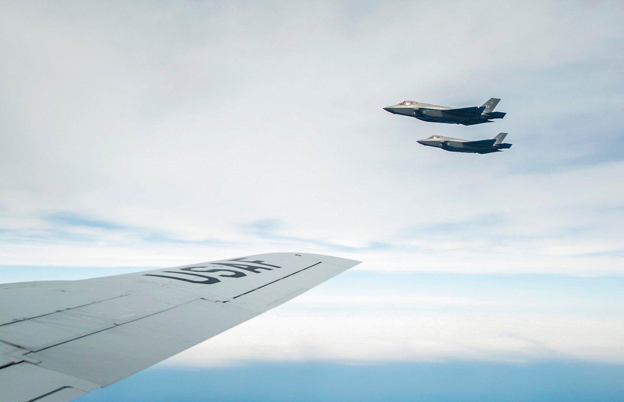 Two F-35A Lightning IIs fly by the KC-135 Stratotanker during a refuel mission over the Gulf of Mexico near Eglin Air Force Base, Fla. March 4.  During the morning mission, local media and 33rd Fighter Wing F-35 maintainers watched as the MacDill Air Force Base KC-135 crew offloaded approximately 48,100 pounds of jet fuel to seven F-35As. The F-35 is the Air Force’s fifth generation fighter. The multi-role fighter’s agility and high performance capabilities increase survivability in high threat environments. (U.S. Air Force photo/Ilka Cole)