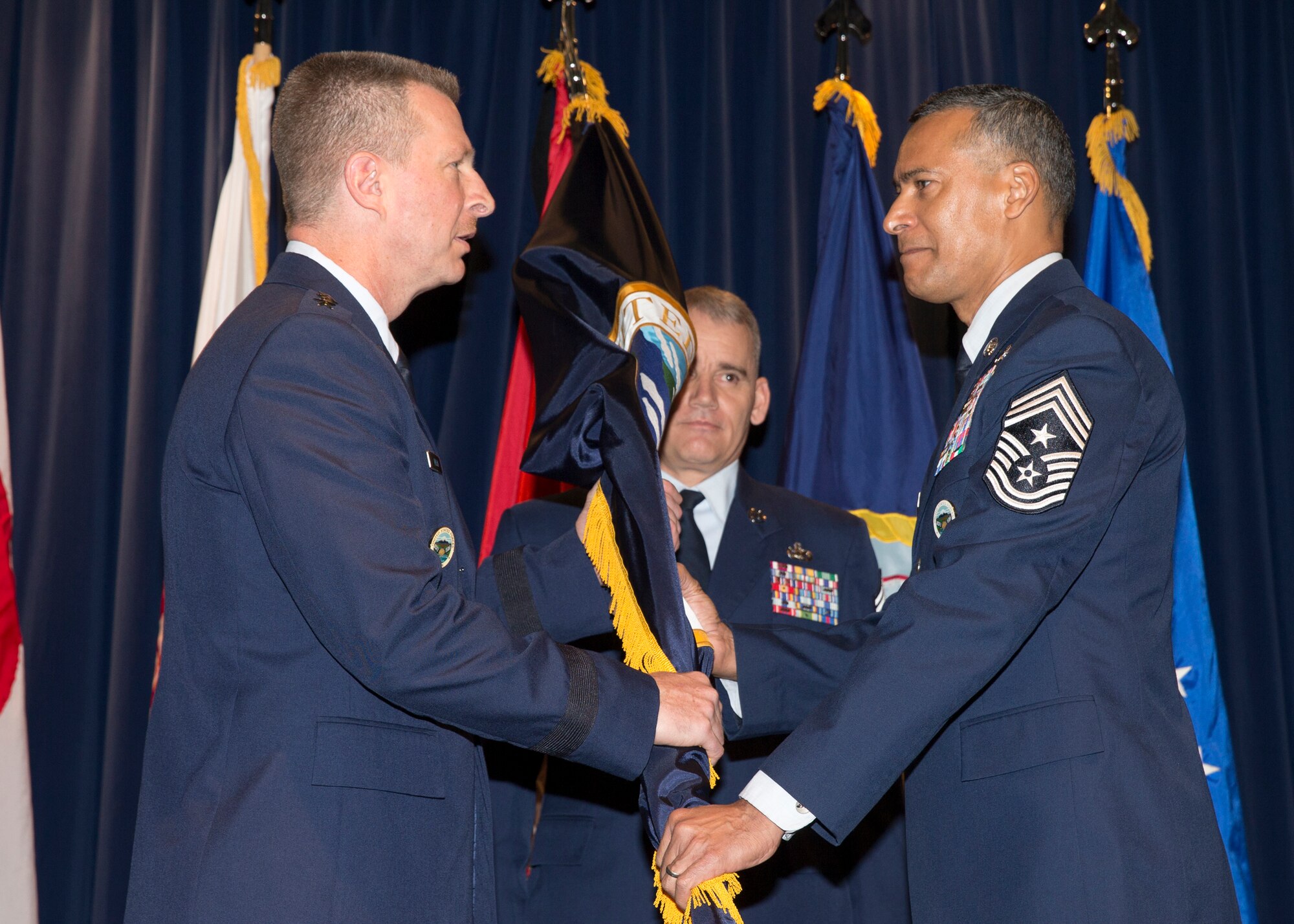 (Right to left) Chief Master Sgt. Terrence Greene, United States Forces Japan and 5th Air Force incoming command chief, receives the USFJ guidon from Lt. Gen. John Dolan, U.S. Forces Japan and 5th AF commander, during a change of responsibility ceremony at Yokota Air Base, Japan, March 10, 2016. Dolan presided over the ceremony. (U.S. Air Force photo by Osakabe Yasuo/Released) 