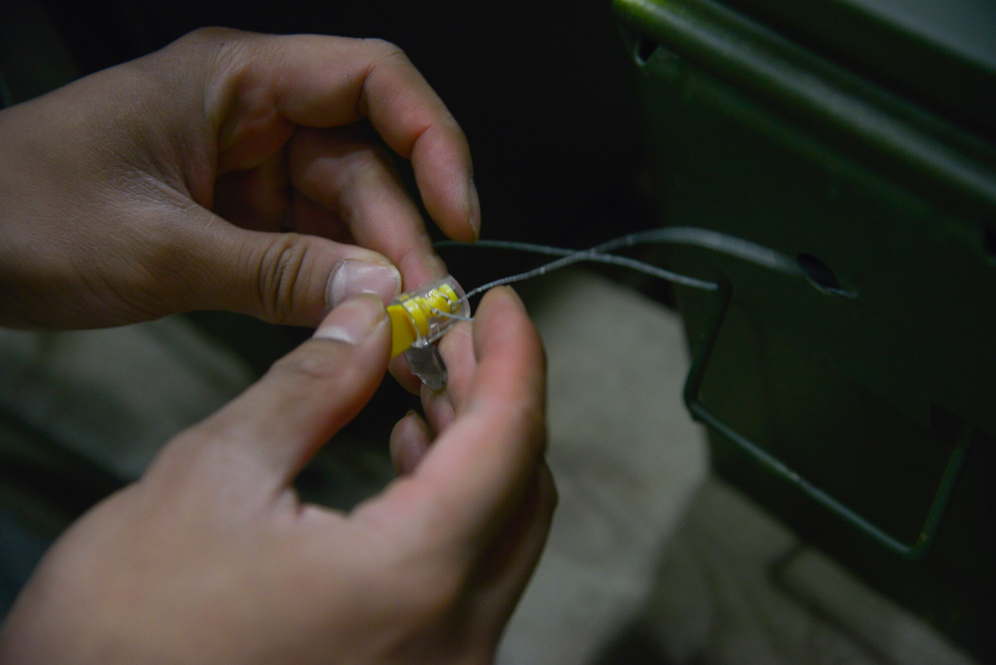 Senior Airman Rhodney Siddayao, 374th Maintenance Squadron Munitions Flight munitions inspector, tightens a seal on a container with flare shells at Yokota Air Base, Japan, Feb. 24, 2016. The C-130 Hercules use M-206 countermeasure flares to counter infrared homing surface-to-air missiles or air-to-air missiles. (U.S. Air Force photo by Senior Airman David Owsianka/Released)
