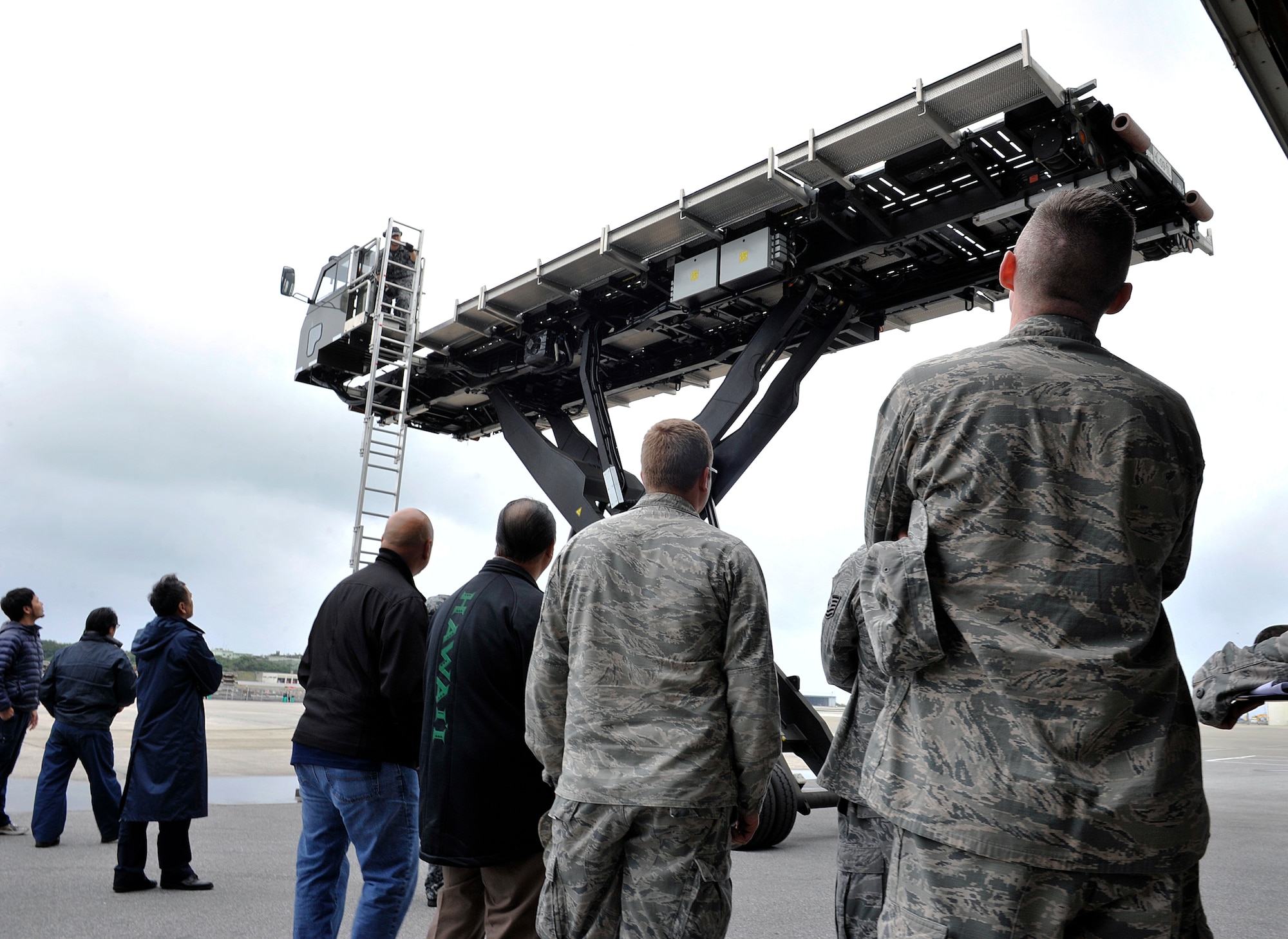Members from the 733rd Air Mobility Squadron observe a high lift loader demonstrated by a Japan Air Self-Defense Force member during their tour, March 10, 2016, at Naha Air Base, Japan. U.S. Air Force Airmen and JASDF partners exchanged ideas and information for improving operational capabilities between the two nations. (U.S. Air Force photo by Naoto Anazawa)



