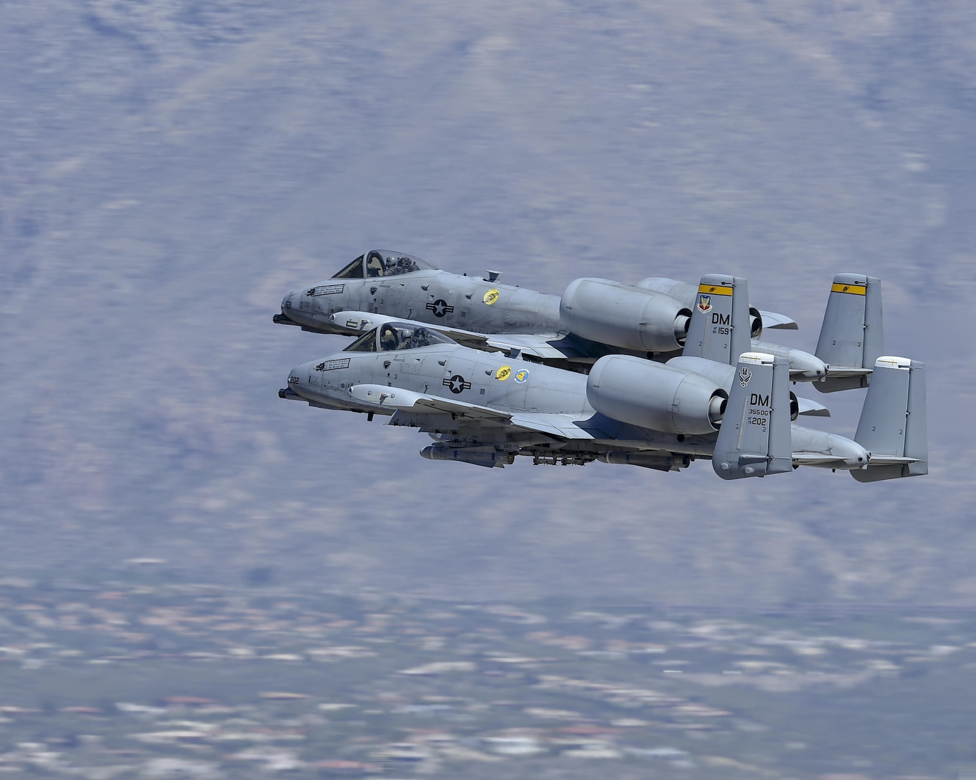 Two A-10C Thunderbolt IIs fly in tandem during a demonstration at the Thunder and Lightning over Arizona Open House at Davis-Monthan Air Force Base, Ariz., March 12, 2016. The Desert Lightning Team demonstration included A-10 Thunderbolt IIs, HH-60G Pave Hawks and an HC-130J Combat King. (U.S. Air Force photo by Senior Airman Chris Massey/Released)