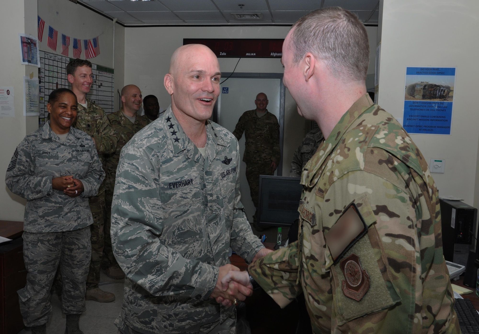 Gen. Carlton Everhart II, Air Mobility Command commander, presents Capt. Michael, 816th Expeditionary Airlift Squadron, with his coin to reward Michael for excellent performance during a visit at Al Al Udeid Air Base, Qatar March 11. Everhart, toured the base and met with several air mobility professionals taking time to thank each one for their contribution to the AMC mission. He also held an all-call on March 13 where he stressed the importance of maintaining readiness and modernizing mobility forces to face future challenges. Photo altered for security purposes. (U.S. Air Force photo by Tech. Sgt. James Hodgman/Released)