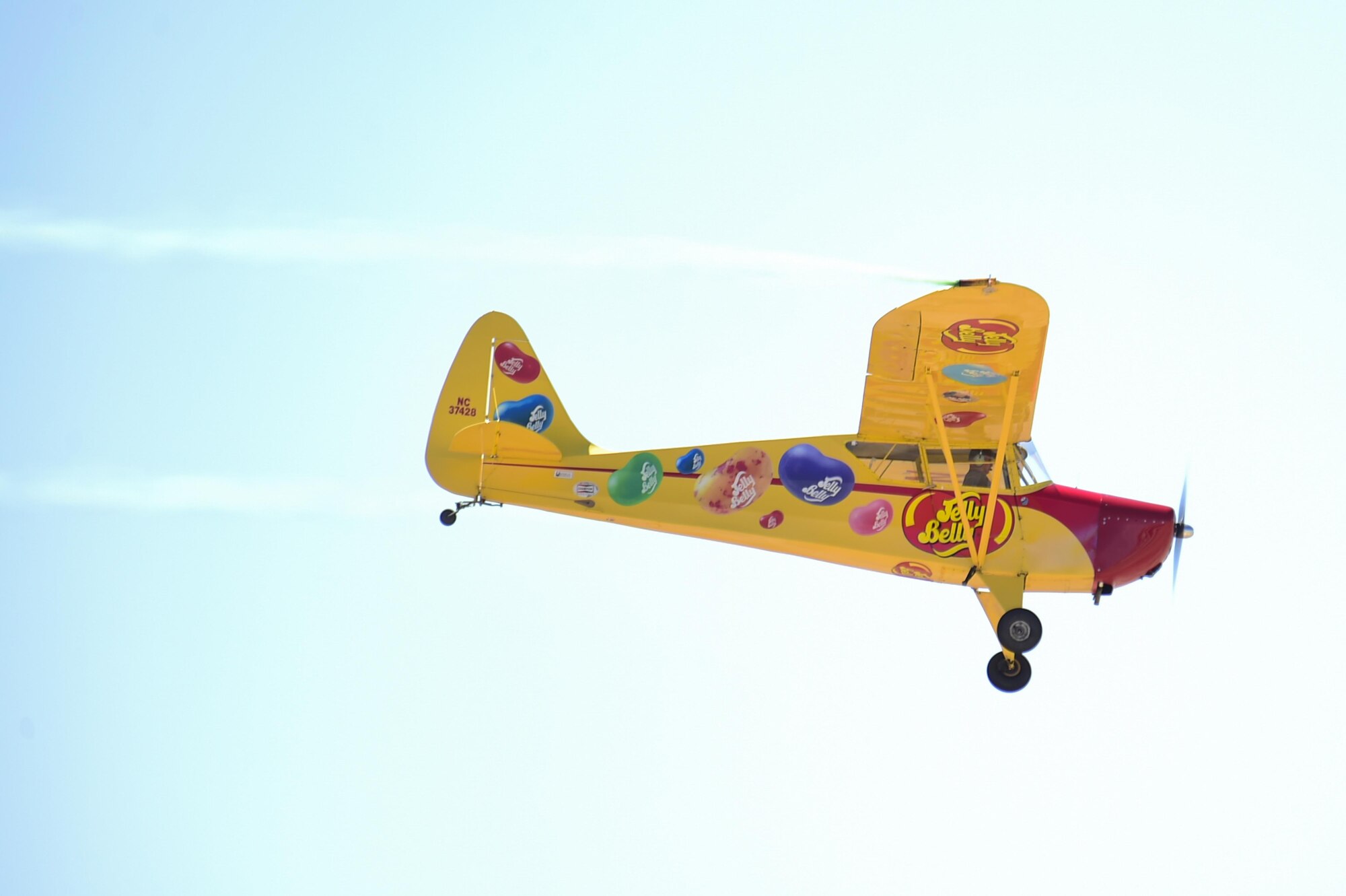 Kent Pietsch and the Jelly Belly airplane perform aerial demonstrations during the Thunder and Lightning over Arizona Open House at Davis-Monthan Air Force Base, Ariz., March 13, 2016. Pietsch flies the 800-pound Interstate Cadet airplane which has a 37-foot wingspan. (U.S. Air Force photo by Senior Airman Chris Massey/Released)