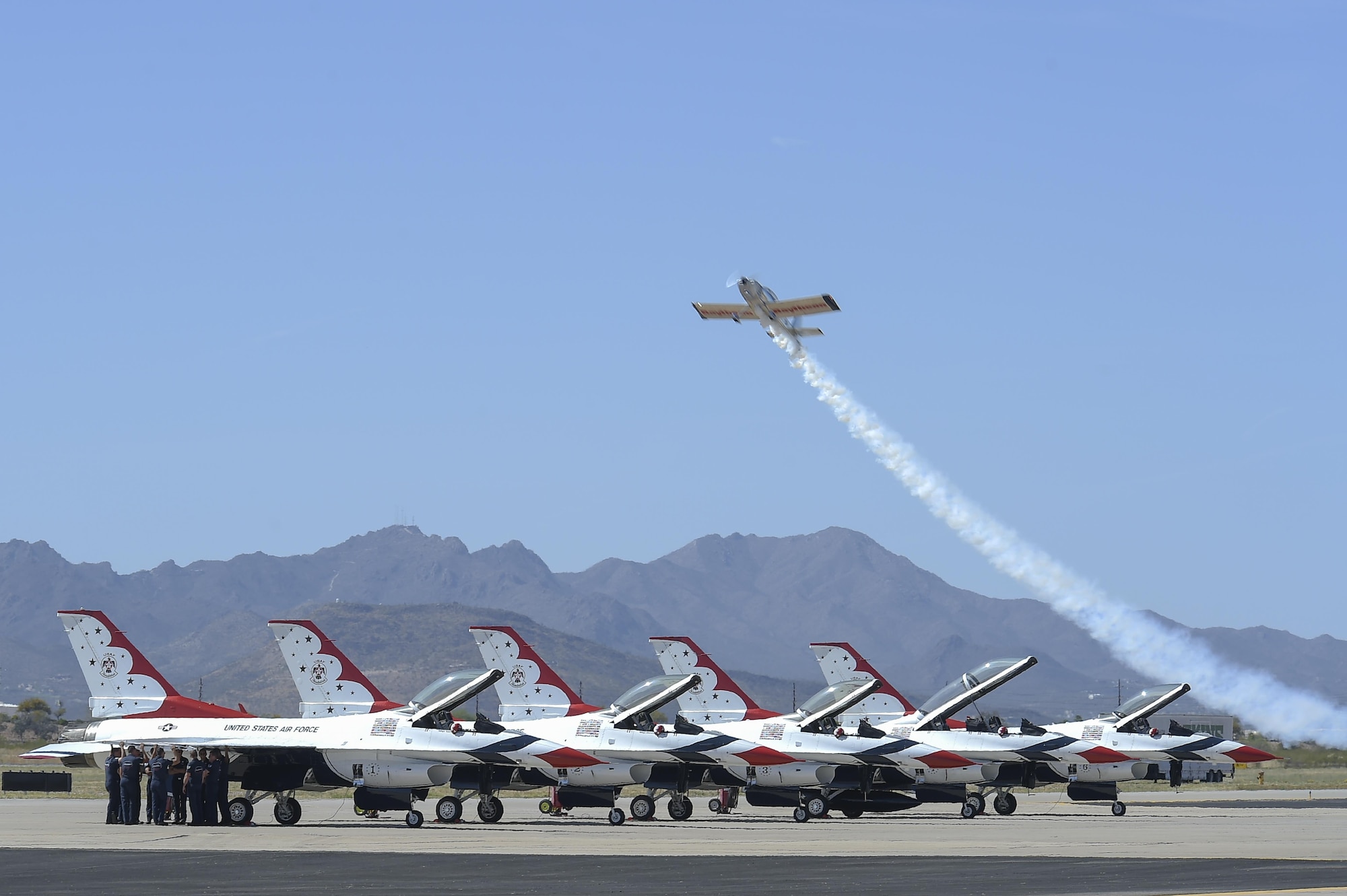 Joe Shetterly, Van’s RV-8 pilot, performs an aerobatic demonstration over five U.S. Air Force Air Demonstration Squadron F-16 Fighting Falcons during the Thunder and Lightning over Arizona Open House event at Davis-Monthan Air Force Base, Ariz., March 13, 2016. The open house featured aerial demonstrations from various teams and numerous static displays allowing the public to gain a better understanding of the Air Force. (U.S. Air Force photo by Senior Airman Chris Massey/Released)