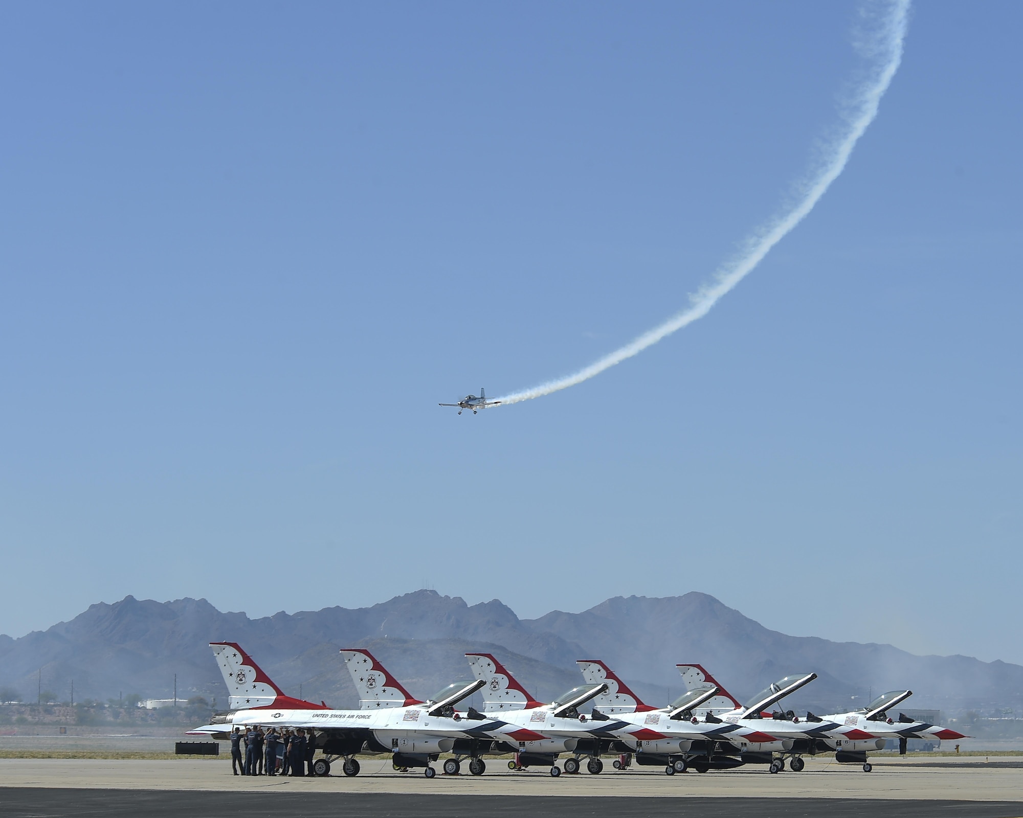 Joe Shetterly, Van’s RV-8 pilot, performs an aerobatic demonstration over five U.S. Air Force Air Demonstration Squadron F-16 Fighting Falcons during the Thunder and Lightning over Arizona Open House event at Davis-Monthan Air Force Base, Ariz., March 13, 2016. The open house featured aerial demonstrations from various teams and numerous static displays allowing the public to gain a better understanding of the Air Force. (U.S. Air Force photo by Senior Airman Chris Massey/Released)