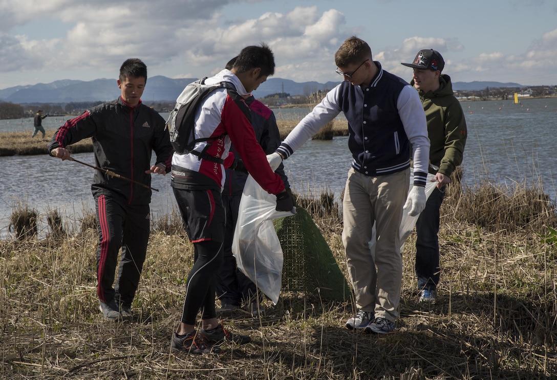 Members of Marine Fighter Attack Squadron (VMFA) 314, forward based at Marine Corps Air Station Iwakuni, Japan; Marine Aviation Logistics Squadron 12; Marine Aircraft Group 12 and Japan Air Self-Defense Force pick of trash during Operation Kibagata at Kibagata Park in Komatsu, Japan, March 12, 2016. Operation Kibagata brought the U.S. and Japan members participating in the Komatsu Aviation Training Relocation Exercise at Komatsu Air Base together to clean the park while providing the opportunity for the two services to socialize. (U.S. Marine Corps photo by Cpl. Nicole Zurbrugg/Released)