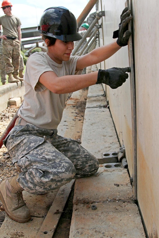 Army Spc. Elizabeth Fernandez secures emergency barriers on the banks of the Ouachita River in Monroe, La., March 13, 2016, during flood response operations. Fernandez, assigned to the Louisiana National Guard’s 1022nd Engineer Company, has been constructing the concrete levees to combat rising river levels caused by excessive rainfall. Army National Guard photo by Spc. Garrett L. Dipuma