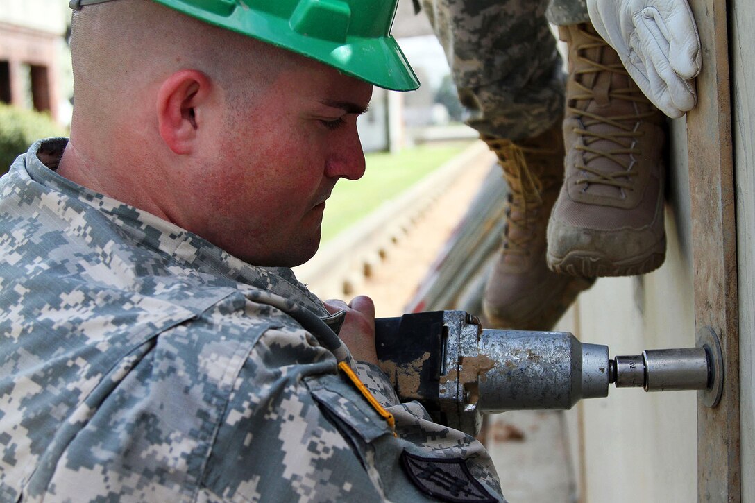 Army Staff Sgt. Tommy Dunlop secures a concrete barrier wall on the banks of the Ouachita River in Monroe, La., March 13, 2016, during flood response operations. Dunlop is assigned to the Louisiana National Guard’s 1022nd Engineer Company. Army National Guard photo by Spc. Garrett L. Dipuma 