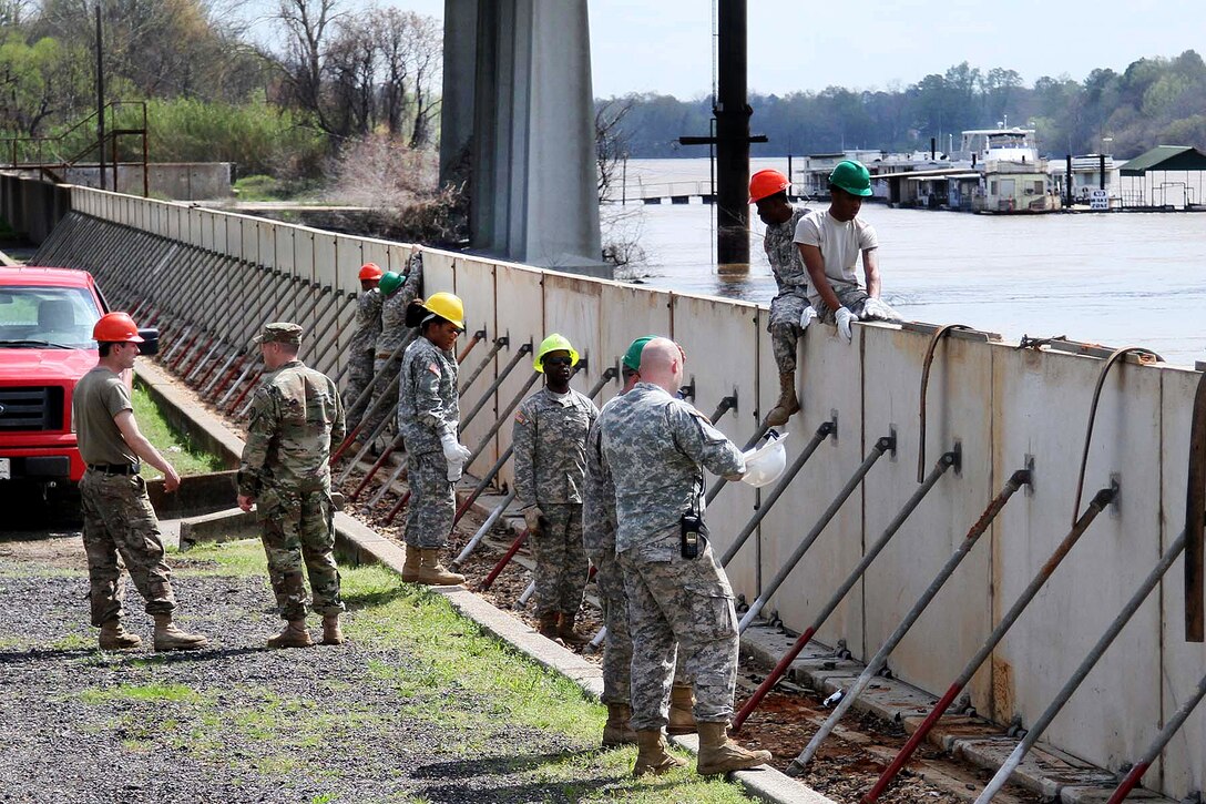 Soldiers assemble emergency levee walls on the banks of the Ouachita River in Monroe, La., March 13, 2016, to protect the city from rising water levels caused by excessive rainfall. The soldiers, assigned to the Louisiana National Guard’s 844th Engineer Company, worked with the Tensas Levee Basin District to transform half a mile of hinged concrete slabs into a 6-foot-tall tall levee. Army National Guard photo by Spc. Garrett L. Dipuma