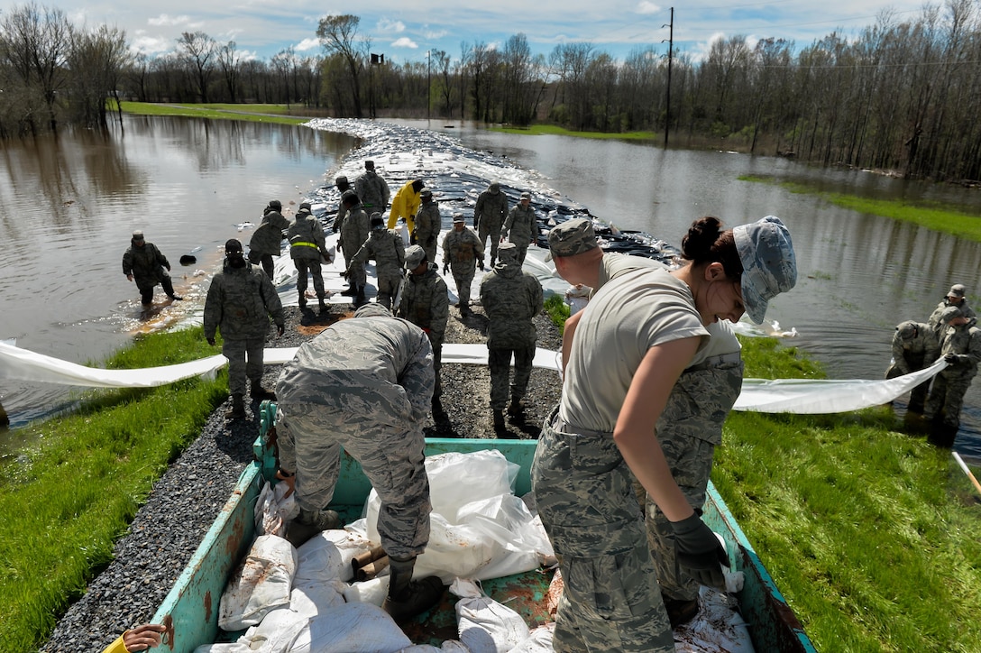 Airmen build a protective barrier over a levee in Bossier City, La., March 10, 2016. Airmen worked in unison with the Army Corps of Engineers and city employees to transport, unload and place sandbags at the lowest sections of the Red Chute Bayou levee. Air Force photo by Senior Airman Mozer O. Da Cunha