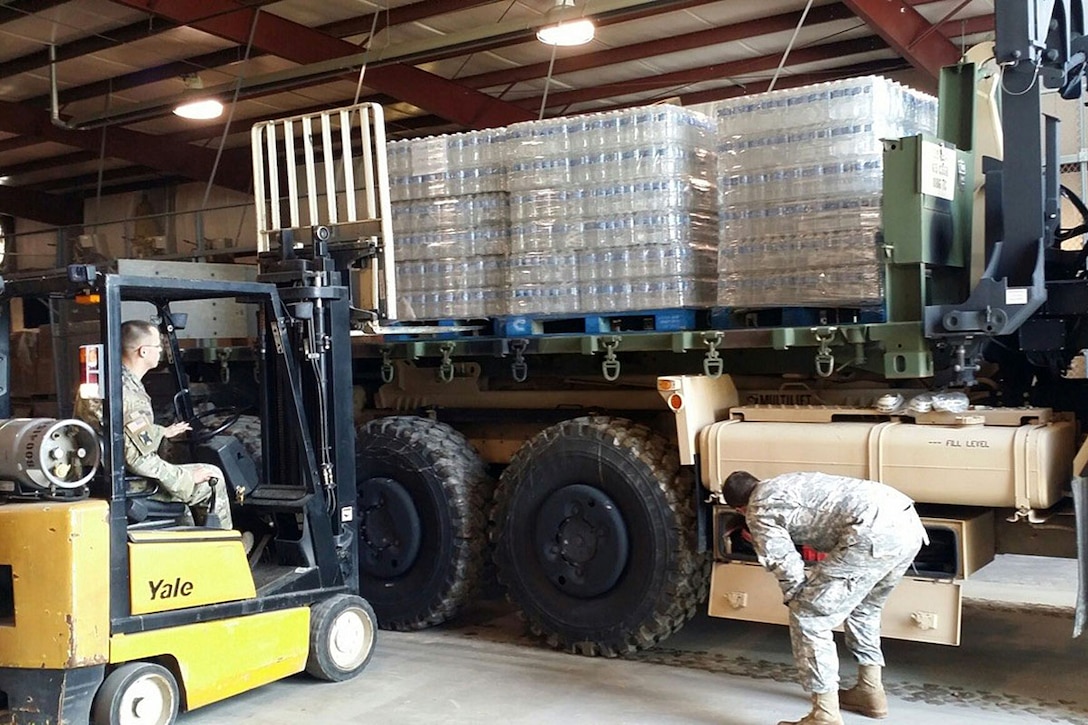 Soldiers load bottles of water for distribution to parishes during emergency flood operations in Bunkie, La., March 13, 2016. The soldiers are assigned to the Louisiana National Guard’s 1086th Transportation Company. Army National Guard photo by Sgt. 1st Class Natalie Wall
