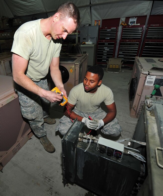 Tech. Sgt. Michael, left, and Airman 1st Class Britain, heating, ventilation and air conditioning technicians assigned to the 380th Expeditionary Civil Engineering Squadron, troubleshoot repairs to an air-conditioning system with a voltmeter at undisclosed location in Southwest Asia, March 2, 2016. A voltmeter, also known as a voltage meter, is an instrument used to measure the difference in voltage between two points in an electronic circuit and can diagnose various problems. (U.S. Air Force photo by Staff Sgt. Kentavist P. Brackin/released)