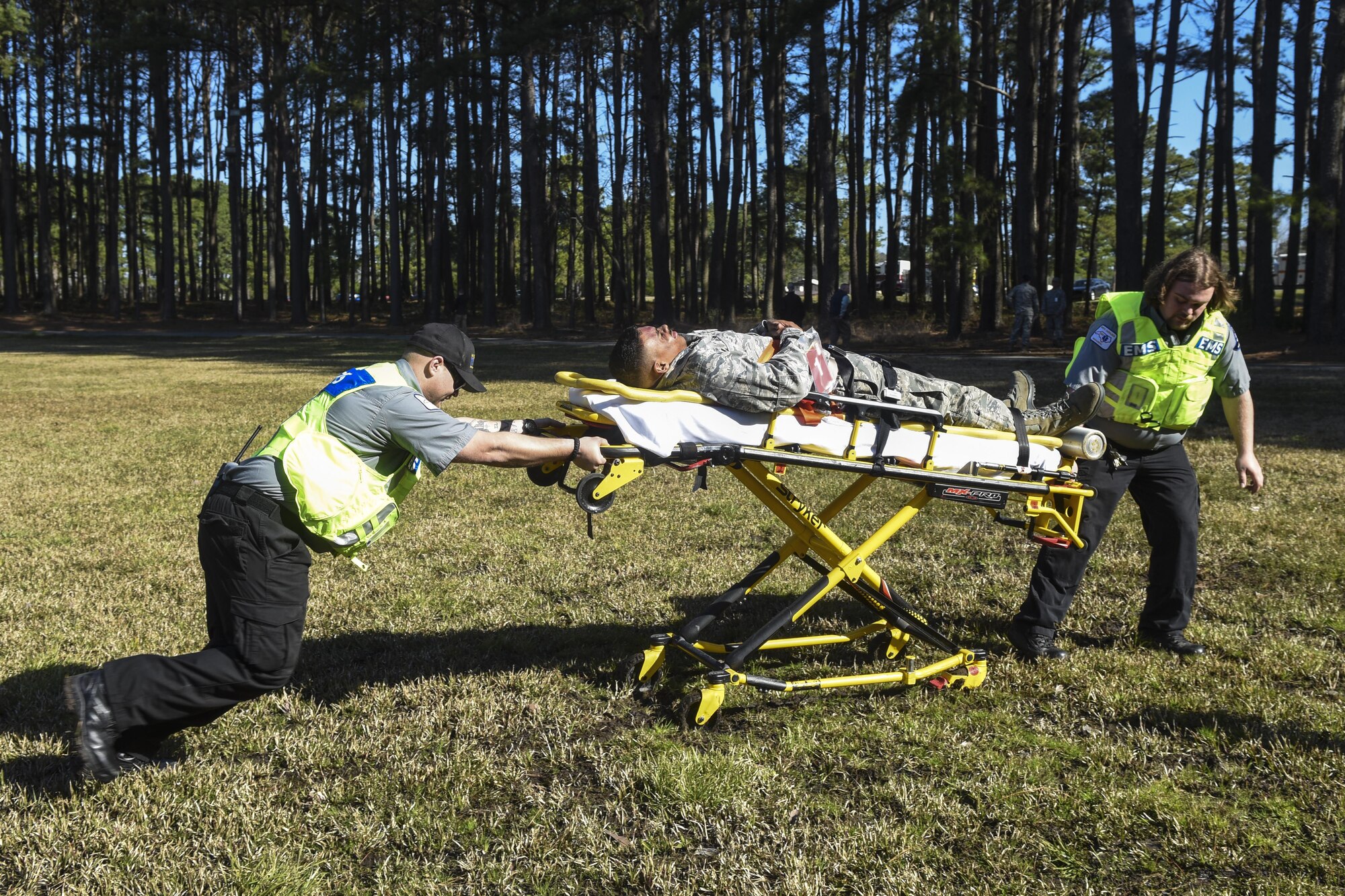Wayne Memorial Hospital emergency medical service members transport an Airman with simulated injuries to a nearby ambulance, March 9, 2016, at Seymour Johnson Air Force Base, North Carolina. Airmen were taken to Wayne Memorial Hospital to practice coordination between the base and the local hospital. (U.S. Air Force photo/Airman Shawna L. Keyes)
