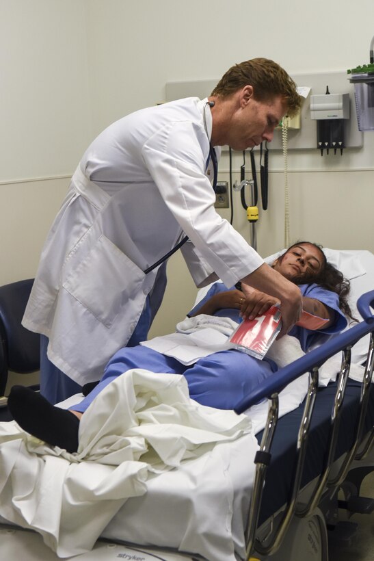 Kirk Jones, Wayne Memorial Hospital emergency medical specialist, attends to Airman Renne Di Giovanni, 4th Civil Engineer Squadron engineering assistant, who has simulated injuries from a suicide bomber during a mass casualty exercise, March 9, 2016, in Goldsboro, North Carolina. The simulations during the exercise helped prepare Team Seymour Airmen and WMH staff on procedures to execute when in the event of a mass casualty incident. (U.S. Air Force photo/Airman Shawna L. Keyes)