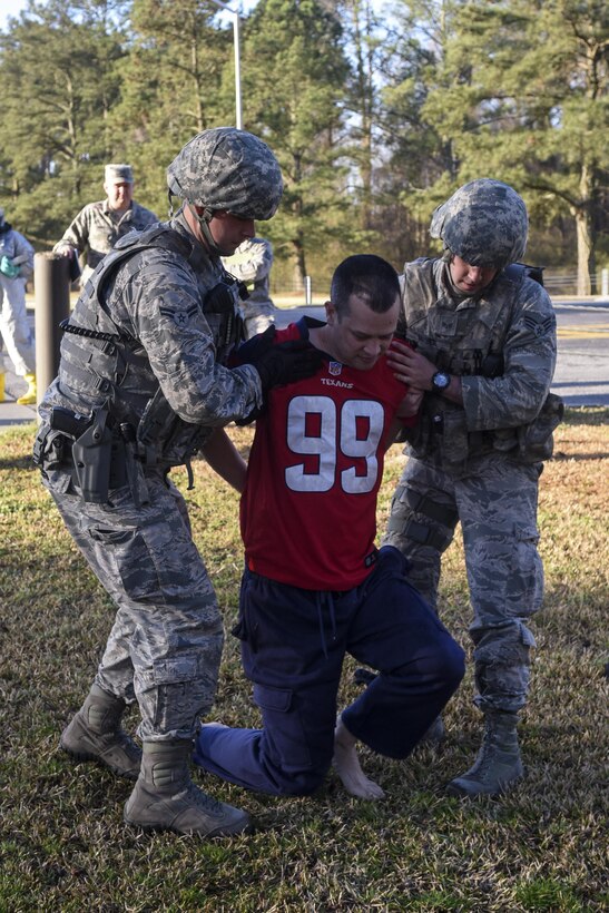 Master Sgt. Michael Owen (center), 4th Fighter Wing inspector general inspections team member, is apprehended by two 4th Security Forces Squadron Airmen during a mass casualty exercise, March 9, 2016, at Seymour Johnson Air Force Base, North Carolina. The exercise tested the effectiveness of Team Seymour and local emergency responders during a mass casualty incident. (U.S. Air Force photo/Airman Shawna L. Keyes)