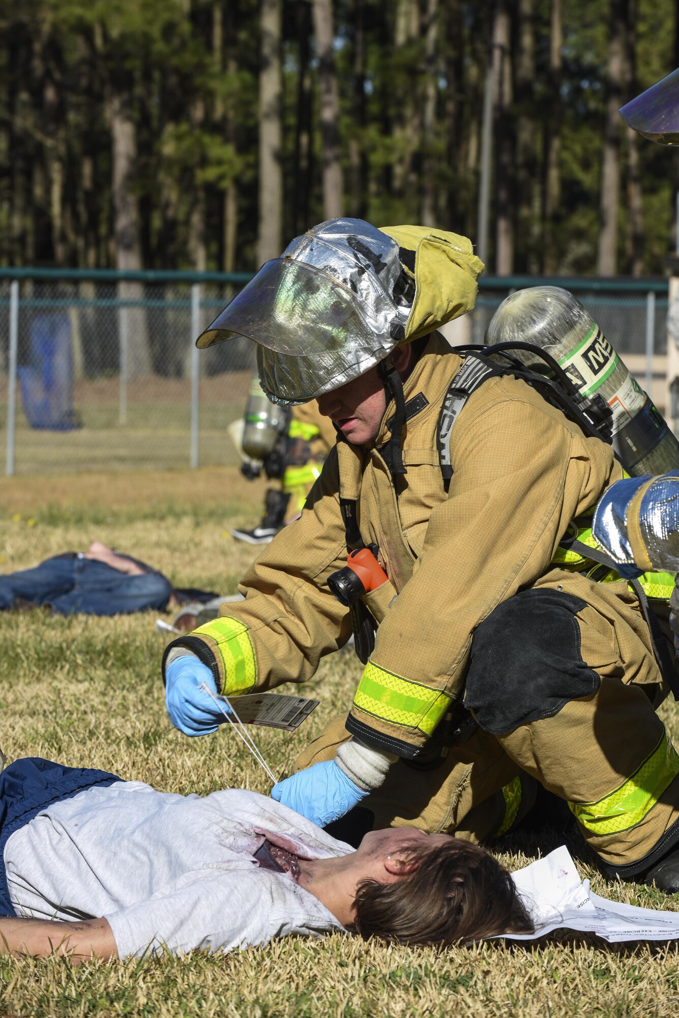 An Airman from the 4th Civil Engineer Squadron fire department provides care to Senior Airman Rosa Salabarria, 4th Communications Squadron knowledge management center technician, during a mass casualty exercise, March 9, 2016, at Seymour Johnson Air Force Base, North Carolina. Members of the 4th Medical Group used moulage to create injuries for a more realistic exercise for emergency responders. (U.S. Air Force photo/Airman Shawna L. Keyes)