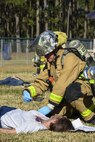 An Airman from the 4th Civil Engineer Squadron fire department provides care to Senior Airman Rosa Salabarria, 4th Communications Squadron knowledge management center technician, during a mass casualty exercise, March 9, 2016, at Seymour Johnson Air Force Base, North Carolina. Members of the 4th Medical Group used moulage to create injuries for a more realistic exercise for emergency responders. (U.S. Air Force photo/Airman Shawna L. Keyes)