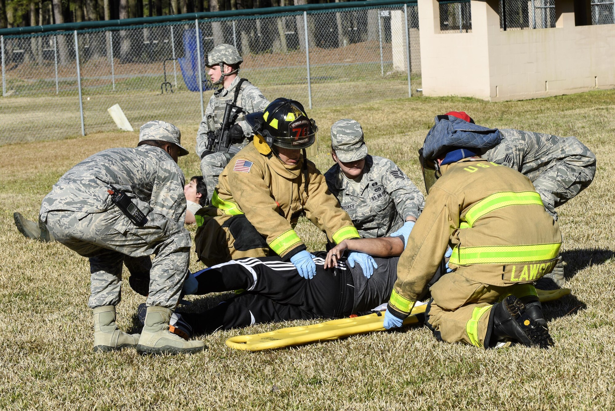 Team Seymour Airmen place a simulated injured Airman onto a gurney, March 9, 2016, at Seymour Johnson Air Force Base, North Carolina. Various medical and emergency agencies on base as well as Wayne County emergency medical services responded to a simulated explosion that injured approximately 40 Airmen during a mass casualty exercise. (U.S. Air Force photo/Airman Shawna L. Keyes)