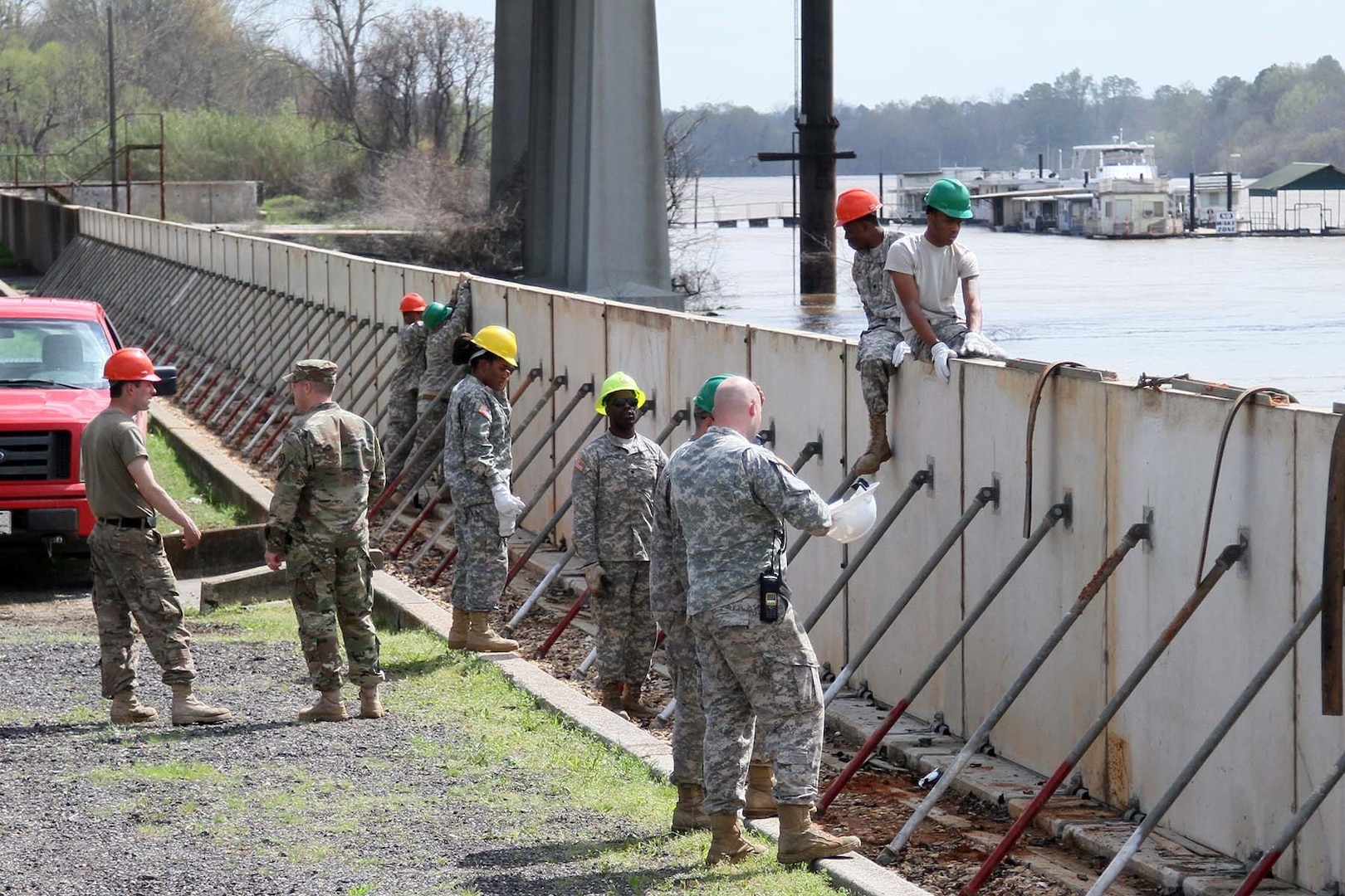 More than 15 Louisiana National Guard members from the 1022nd Engineer Company and the 844th Engineer Company out of West Monroe are assembling emergency levee walls on the banks of the Ouachita River in Monroe on March 13, 2016, to protect the city from rising river levels caused by excessive rainfall. The Soldiers are working in conjunction with the Tensas Levee Basin District to transform half a mile of hinged concrete slabs, which are usually the sidewalk alongside the river, into a six-foot tall levee. 