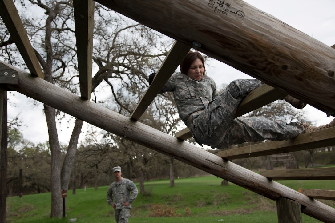 U.S. Army Sgt. Marcy DiOssi assigned to the 102nd Training Division of Ft. Leonard Wood, Mo., navigates the Weaver obstacle at the Obstacle Course event during the 80th Training Command 2016 Best Warrior Competition (BWC) in conjunction with the 99th Regional Support Command at Camp Bullis, Texas, March 11, 2016. The BWC is an annual competition to identify the strongest and most well-rounded Soldiers through the accomplishment of physical and mental challenges, as well as basic Soldier skills. (U.S. Army photo by Cpl. Cope Steven).