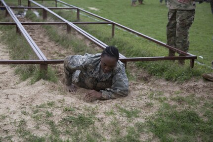 U.S. Army Spc. Yvonne Wiggins assigned to the 7th of the 95th Joint Reserve Base of Grand Prairie, Texas, navigates the Low Crawl obstacle at the Obstacle Course event during the 80th Training Command 2016 Best Warrior Competition (BWC) in conjunction with the 99th Regional Support Command at Camp Bullis, Texas, March 11, 2016. The BWC is an annual competition to identify the strongest and most well-rounded Soldiers through the accomplishment of physical and mental challenges, as well as basic Soldier skills. (U.S. Army photo by Cpl. Cope Steven).