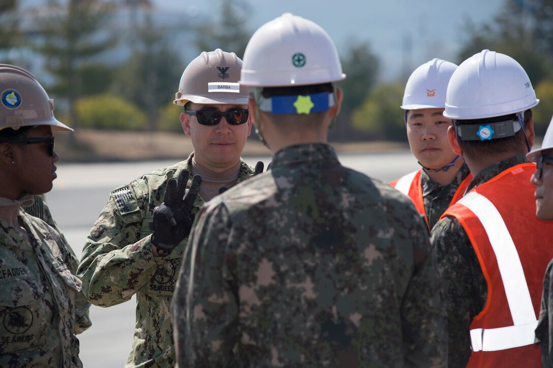 Navy Petty Officer 1st Class Oscar Barba organizes teams with South Korean Seabees prior to airfield damage repair training during exercise Foal Eagle 2016 in Jinhae, South Korea, March 15, 2016. Foal Eagle is an annual, bilateral training exercise designed to enhance the readiness of U.S. and South Korean forces and their ability to work together during a crisis. Barba is assigned to Naval Mobile Construction Battalion 4. Navy photo by Chief Lowell Whitman