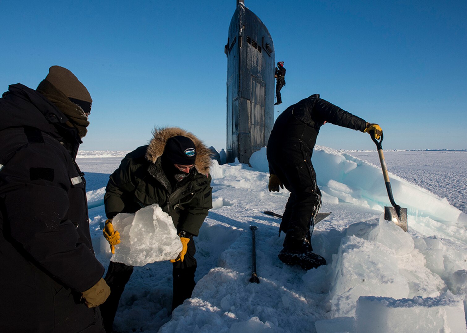 ARCTIC CIRCLE (March 14, 2016) Sailors and civilians, assigned to Arctic Submarine Lab, clear the ice from the hatch of USS Hampton (SSN 767) during Ice Exercise (ICEX) 2016. ICEX 2016 is a five-week exercise designed to research, test, and evaluate operational capabilities in the region. ICEX 2016 allows the U.S. Navy to assess operational readiness in the Arctic, increase experience in the region, advance understanding of the Arctic environment, and develop partnerships and collaborative efforts. 
