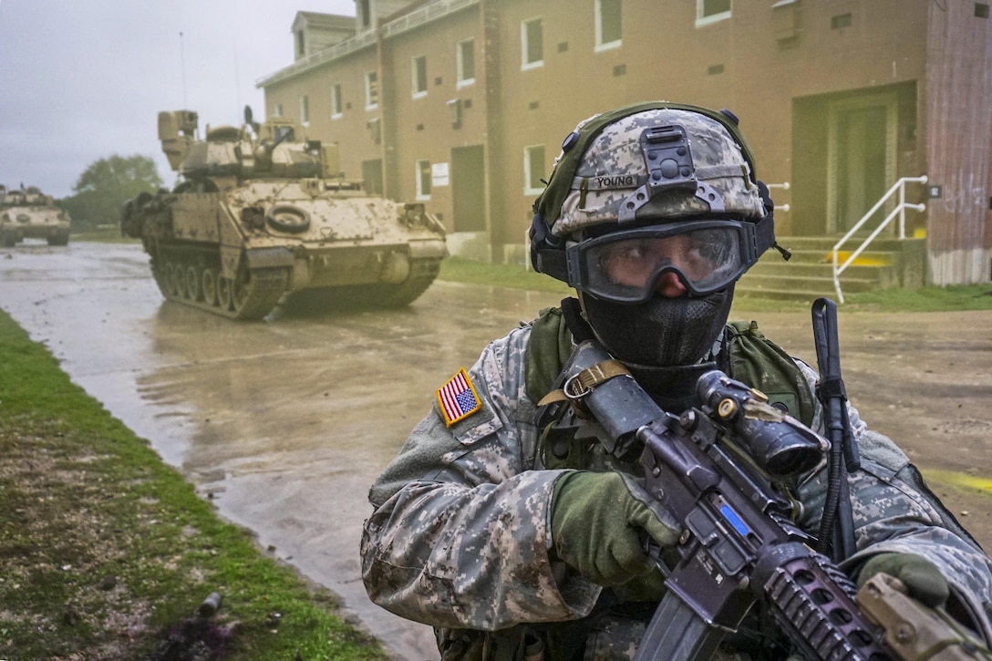 A soldier moves through an urban training facility and uses simulated rounds to enhance the training's realism on Fort Hood, Texas, March 10, 2016. The soldier is assigned to the 1st Cavalry Division's Company B, 2nd Battalion, 7th Cavalry Regiment, 3rd Armored Brigade Combat Team. Army photo by Sgt. Brandon Banzhaf