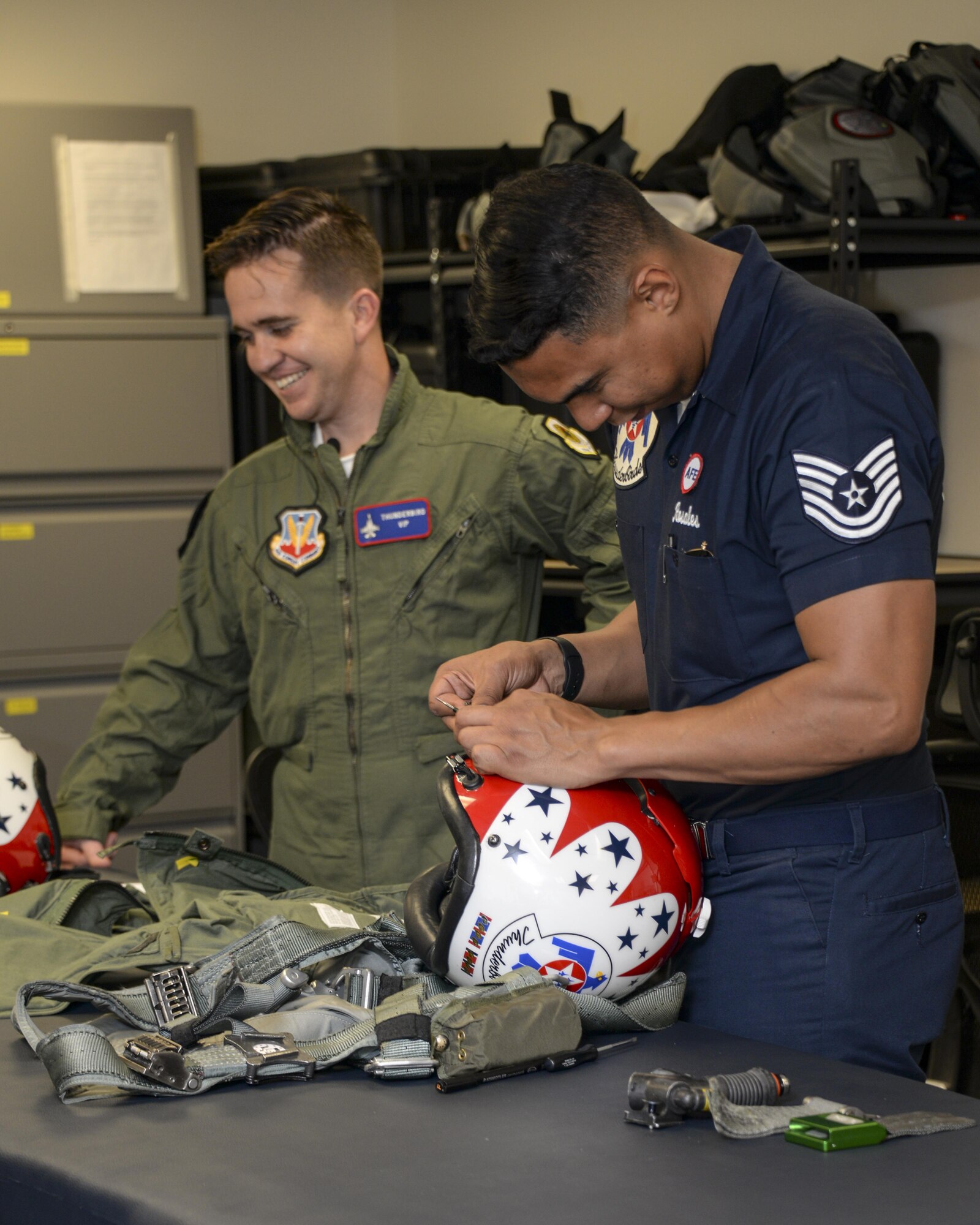 U.S. Air Force Tech. Sgt. Paul Rosales, aircrew flight equipment specialist with the U.S. Air Force Air Demonstration Squadron, right, shares a laugh with Brendan Lyons, Tucson community hometown hero, as he adjusts the fit of a helmet at Davis-Monthan Air Force Base, Ariz., March 11, 2016.  Lyons was nominated as a hometown hero to fly with the Thunderbirds because of his commitment to safety and his passion to make Tucson a safer community for cyclists and motorists.  (U.S. Air Force photo by Senior Airman Chris Massey/Released)