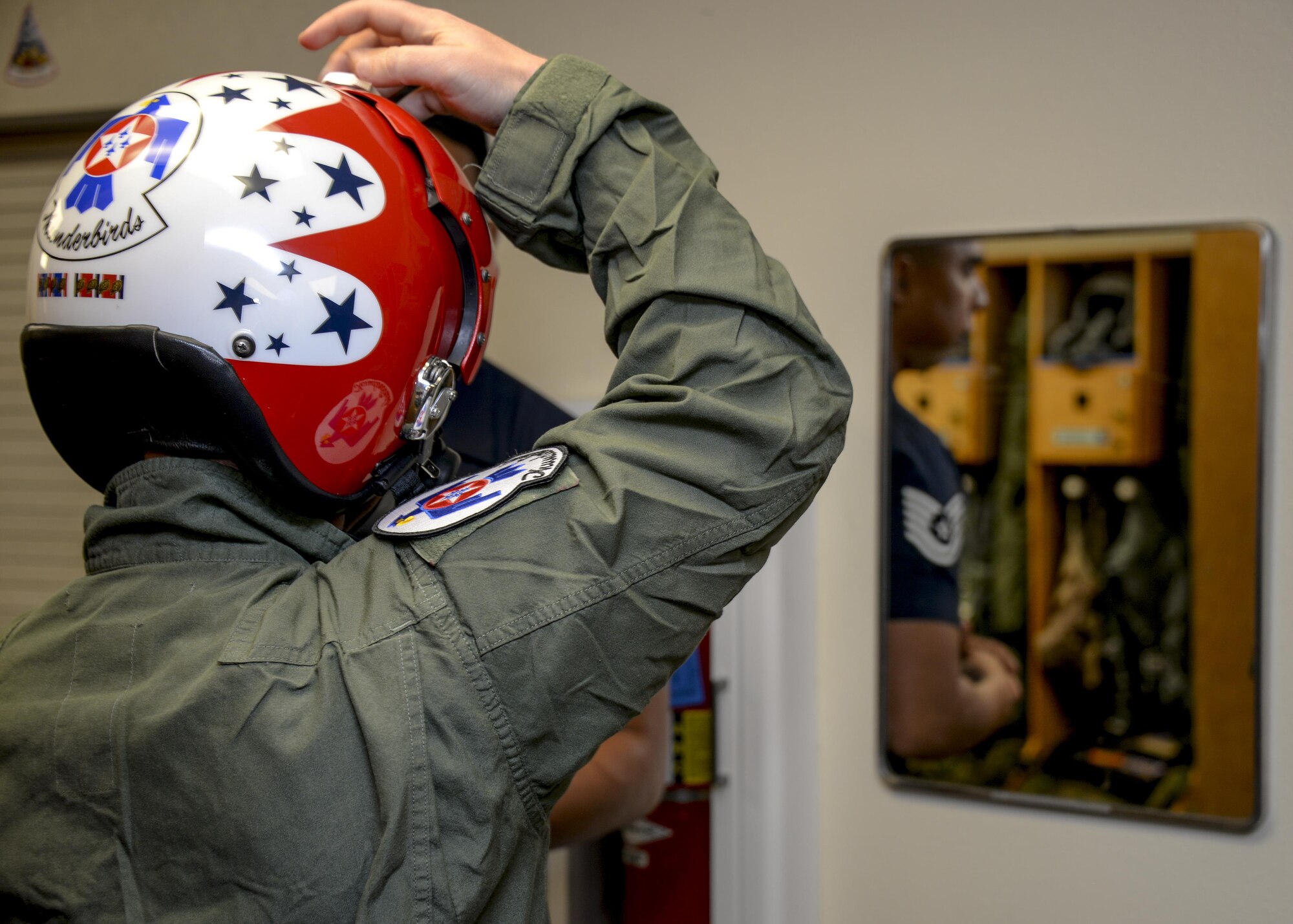 Brendan Lyons, Tucson community hometown hero, works with U.S. Air Force Tech. Sgt. Paul Rosales, aircrew flight equipment specialist with the U.S. Air Force Air Demonstration Squadron, to ensure a secure fit of a helmet and oxygen mask at Davis-Monthan Air Force Base, Ariz., March 11, 2016.  Lyons was nominated as a hometown hero to fly with the Thunderbirds because of his commitment to safety and his passion to make Tucson a safer community for cyclists and motorists.  (U.S. Air Force photo by Senior Airman Chris Massey/Released)
