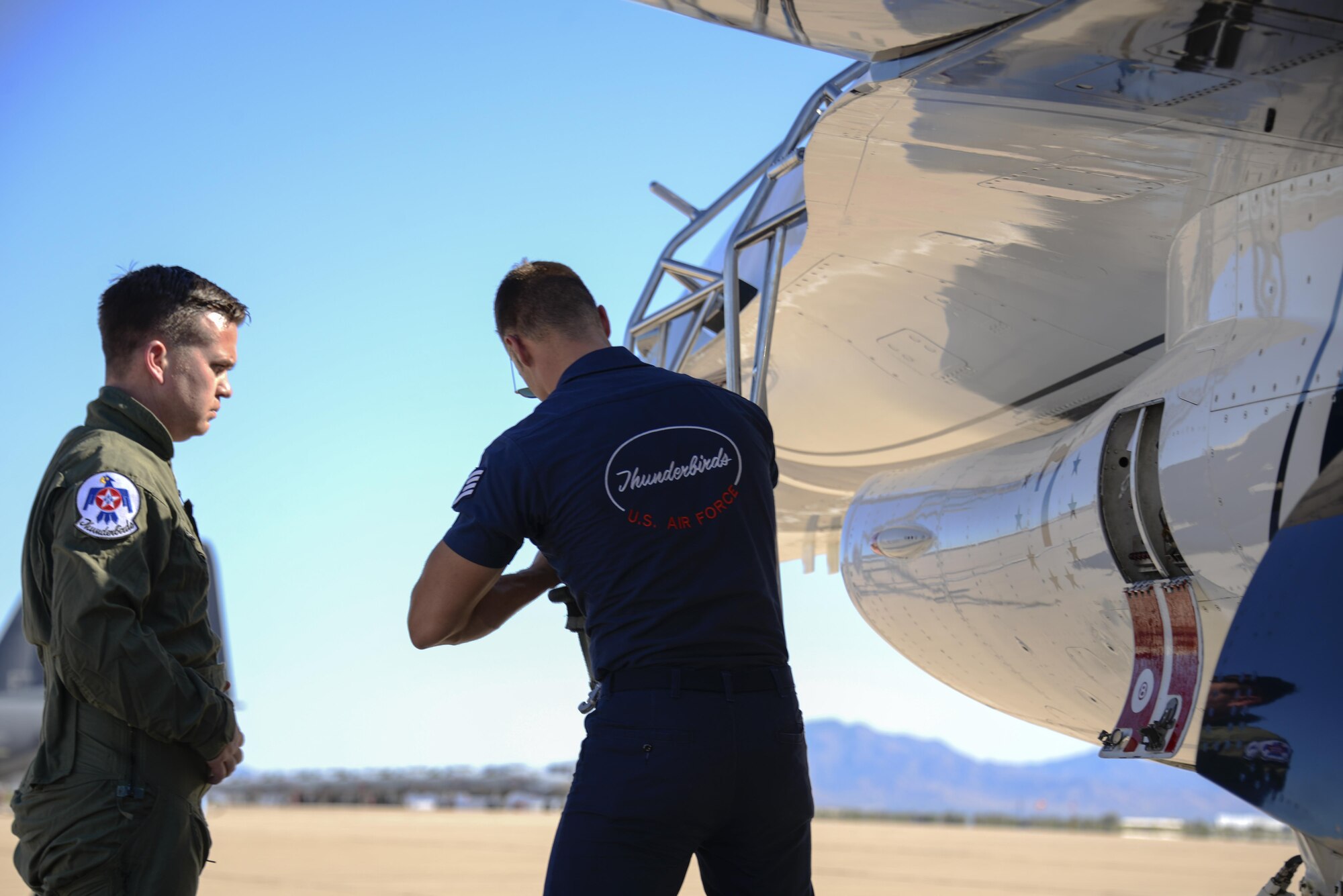 Brendan Lyons, Tucson community hometown hero, waits to be fitted with a G-suit harness by U.S. Air Force Staff Sgt. Conrad Nelson, from the U.S. Air Force Air Demonstration Squadron, prior to his flight in Thunderbird 7, an F-16 Fighting Falcon, at Davis-Monthan Air Force Base, Ariz., March 11, 2016.  Lyons was nominated as a hometown hero to fly with the Thunderbirds because of his commitment to safety and his passion to make Tucson a safer community for cyclists and motorists.  (U.S. Air Force photo by Senior Airman Chris Massey/Released)