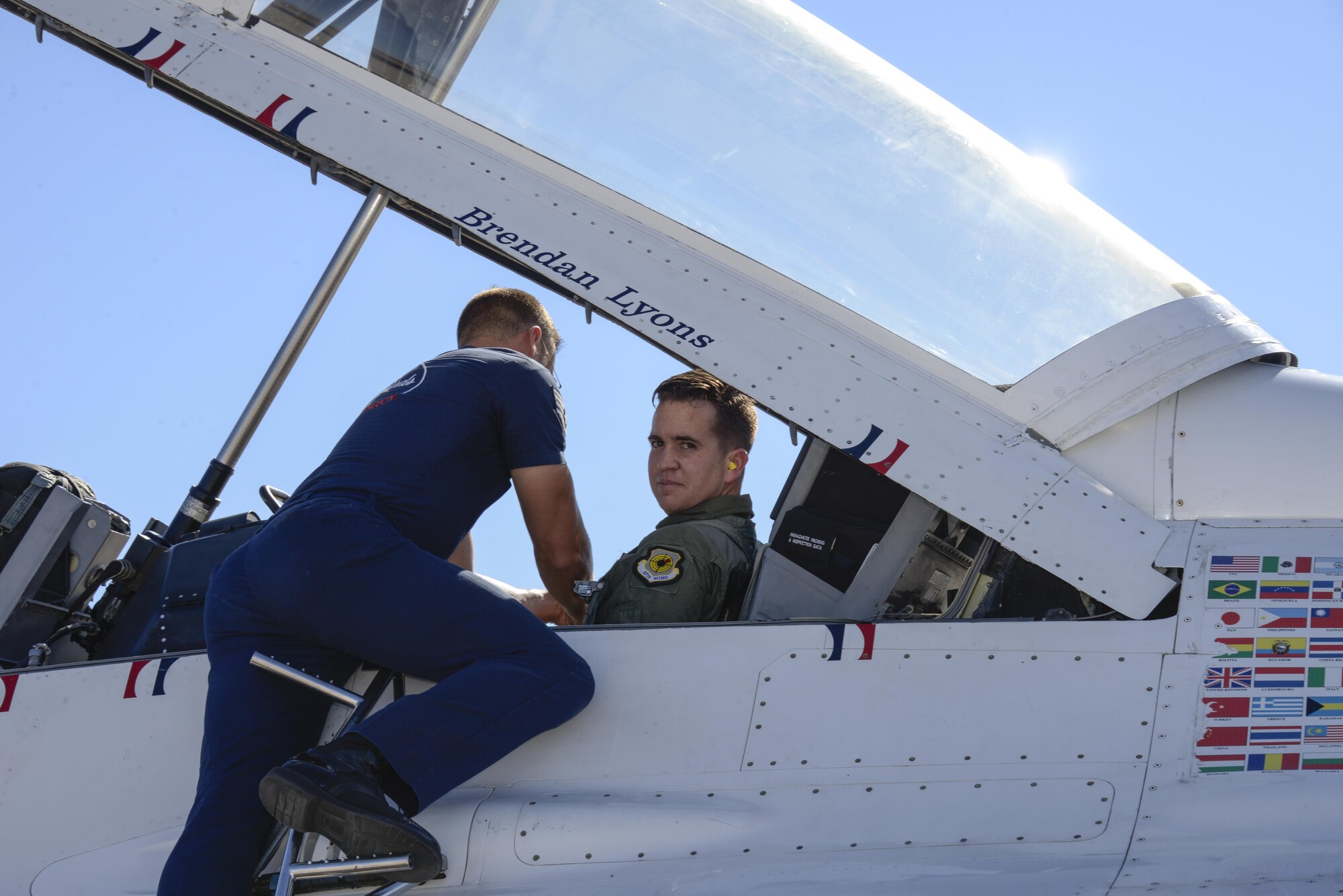 U.S. Air Force Staff Sgt. Conrad Nelson, from the U.S. Air Force Air Demonstration Squadron, secures Brendan Lyons, Tucson community hometown hero, in Thunderbird 7, an F-16 Fighting Falcon, at Davis-Monthan Air Force Base, Ariz., March 11, 2016.  Lyons was nominated as a hometown hero to fly with the Thunderbirds because of his commitment to safety and his passion to make Tucson a safer community for cyclists and motorists.  (U.S. Air Force photo by Senior Airman Chris Massey/Released)