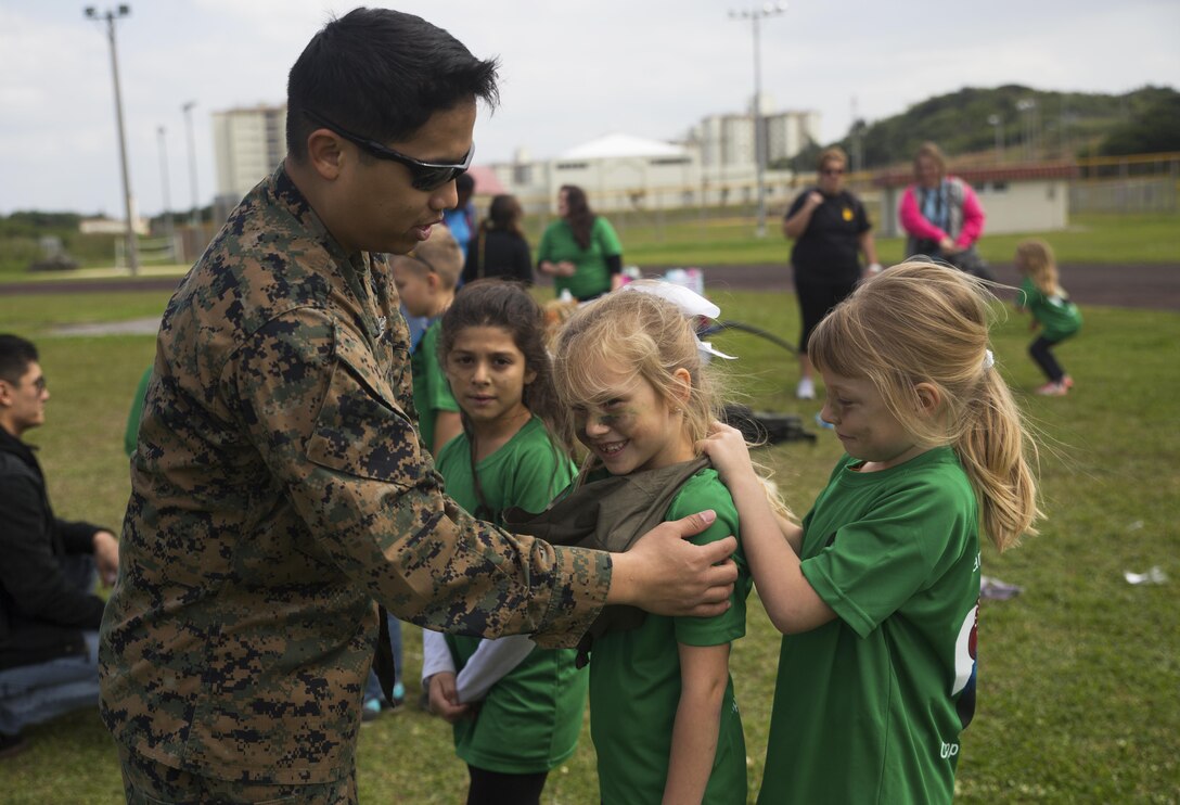 Seaman Miguelanto S. Lugtu demonstrates how to splint a broken arm on a member of Girl Scout Troop 435 during a Jane Wayne Day March 12 aboard Camp Kinser, Okinawa, Japan. Jane Wayne Day is an event designed to allow spouses and children to gain a better understanding of some of the physical challenges military service members face. During the event, participants learned about radios, the Marine Corps Martial Arts Program, ran a modified combat fitness test, perused medical equipment and donned chemical, biological, radiological, nuclear defense equipment. The troop took on the many challenges of the day as a celebration of the Girl Scout Birthday. Lugtu is a corpsman with Headquarters Regiment, 3rd Marine Logistics Group, III Marine Expeditionary Force and a Portsmouth, Virginia, native.