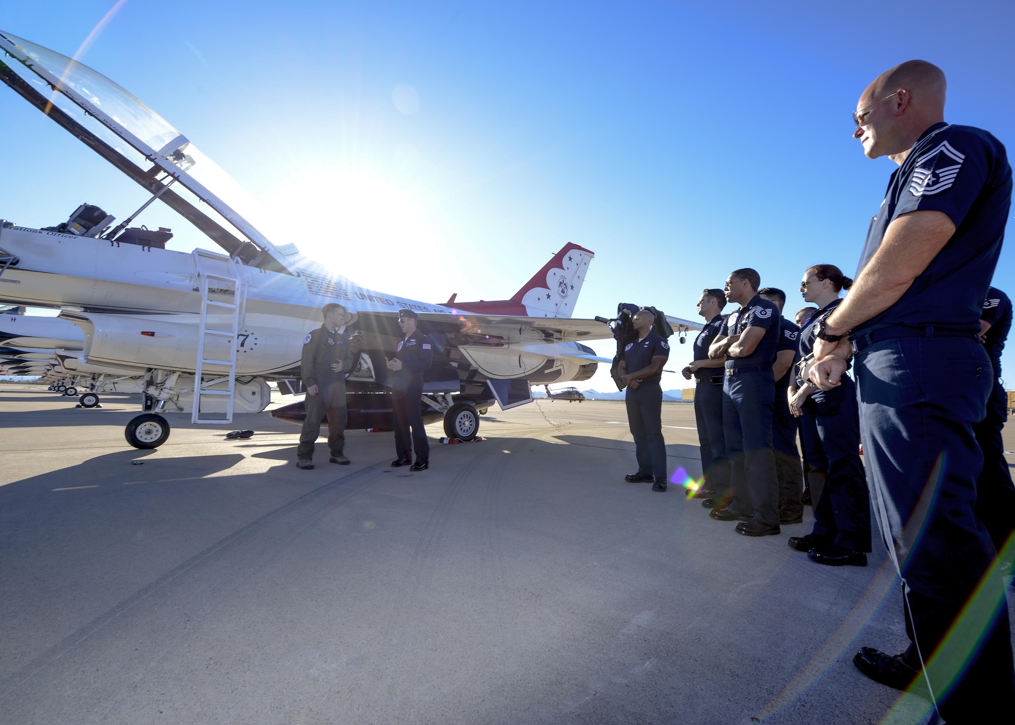 U.S. Air Force Air Demonstration Squadron aircrew watch as Brendon Lyons, Tucson community hometown hero, speaks about his experience immediately after his flight in Thunderbird 7, an F-16 Fighting Falcon, with Maj. Kevin Walsh, Thunderbird pilot and operations officer, at Davis-Monthan Air Force Base, Ariz., March 11, 2016.  Lyons was nominated as a hometown hero because of his commitment to safety and his passion to make Tucson a safer community for cyclists and motorists.  (U.S. Air Force photo by Senior Airman Chris Massey/Released)