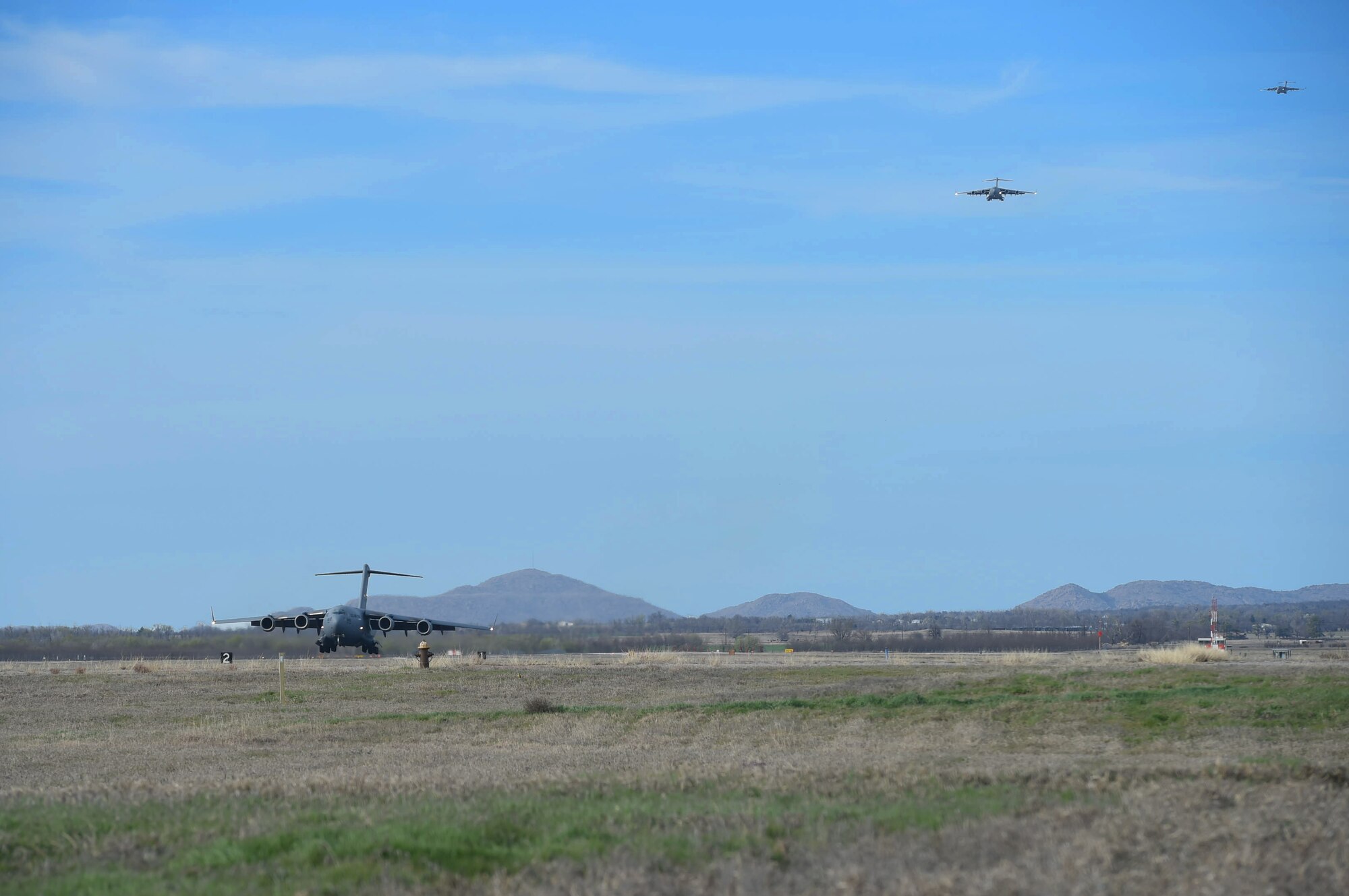 A three-ship formation of U.S. Air Force C-17 Globemaster III cargo aircraft prepare to land, March 4, 2016, on the flightline at Altus Air Force Base, Okla. Eight aircraft from Altus AFB met with four additional aircraft from Travis Air Force Base, Calif. and Joint Base Lewis-McChord, Wash. to realistically train U.S. Air Force aircrew members for future multi-base operations. (U.S. Air Force photo by Senior Airman Dillon Davis)

