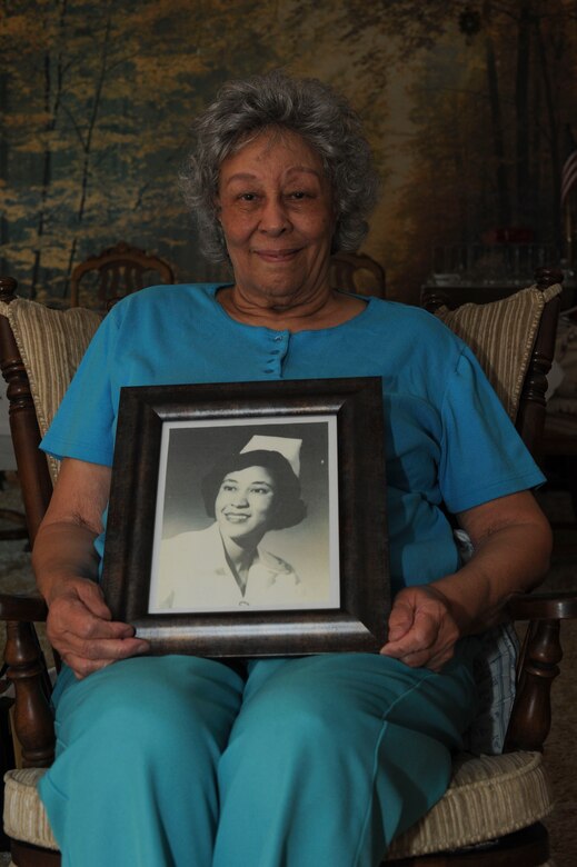 Retired Lt. Col Mattie Boyd, poses with a photo of herself when she was younger, Mar. 3, 2016, at her home in Wichita, Kan. Boyd is a 26-year veteran who commissioned as a first lieutenant in the Reserve Nurse Corps in 1963. (U.S. Air Force photo/Airman Jenna K. Caldwell)  