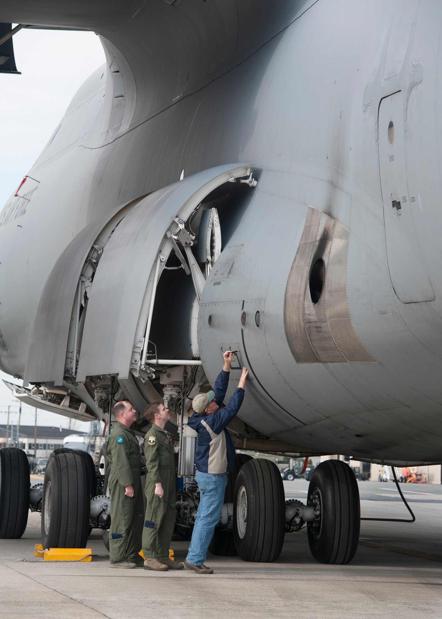 Ralph Kellenberger, FlightSafety flight engineer instructor, walks Tech. Sgt. Ryan Berry, 312th Airlift Squadron flight engineer, and Master Sgt. James Spinner, 9th AS flight engineer, through C-5M Super Galaxy pre-fight procedures during initial qualification training March 10, 2016, at Dover Air Force Base, Del. FlightSafety operates on Dover AFB as a contractor that trains Air Force pilots and flight engineers. (U.S. Air Force photo/Senior Airman Zachary Cacicia)