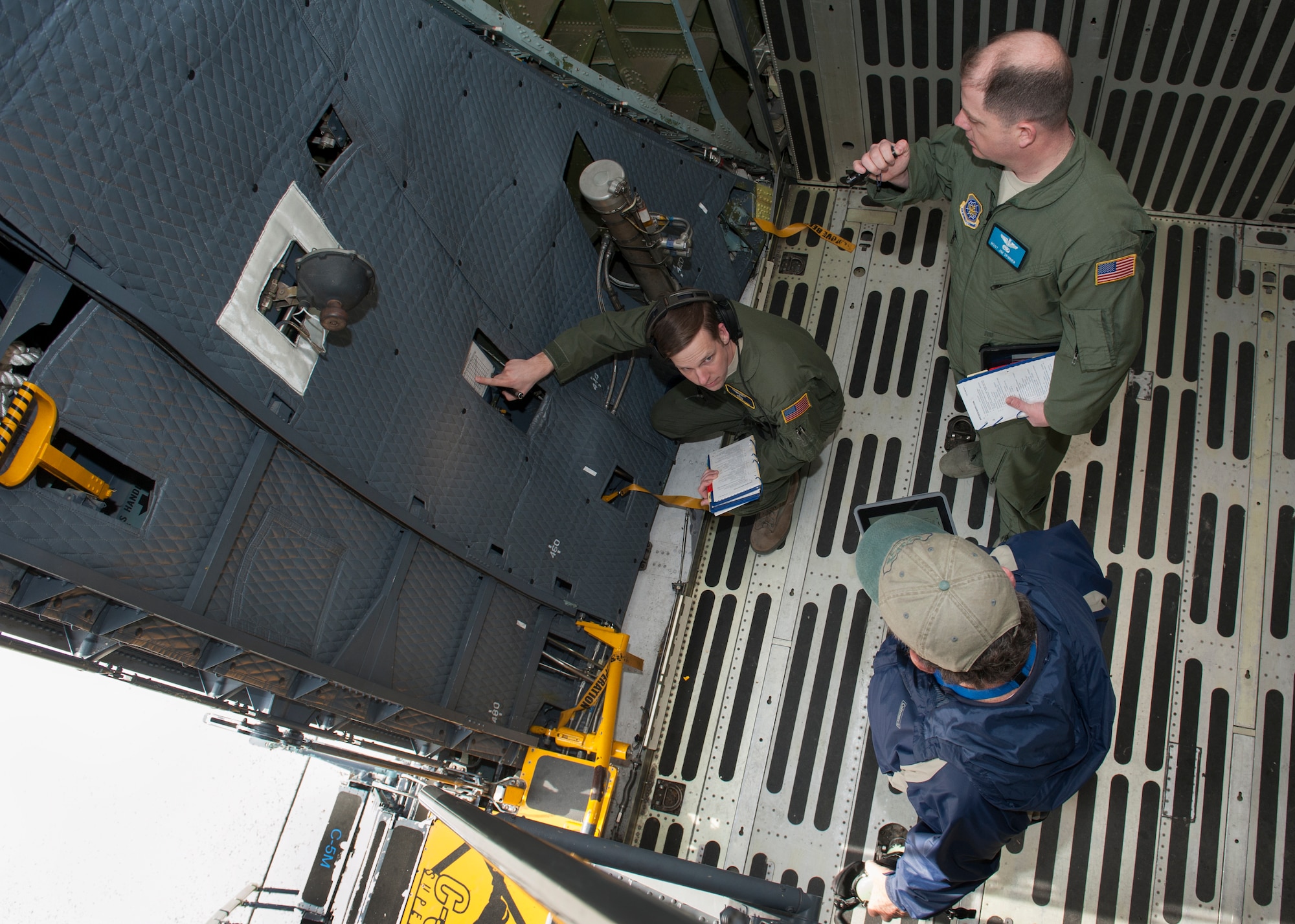 Ralph Kellenberger, FlightSafety flight engineer instructor, takes Tech. Sgt. Ryan Berry, 312th Airlift Squadron flight engineer, and Master Sgt. James Spinner, 9th AS flight engineer, through C-5M Super Galaxy pre-fight procedures during initial qualification training March 10, 2016, inside a C-5M on Dover Air Force Base, Del. All Team Dover flight engineer and pilot students go through FlightSafety prior to being sent to the Formal Training Unit. (U.S. Air Force photo/Senior Airman Zachary Cacicia)