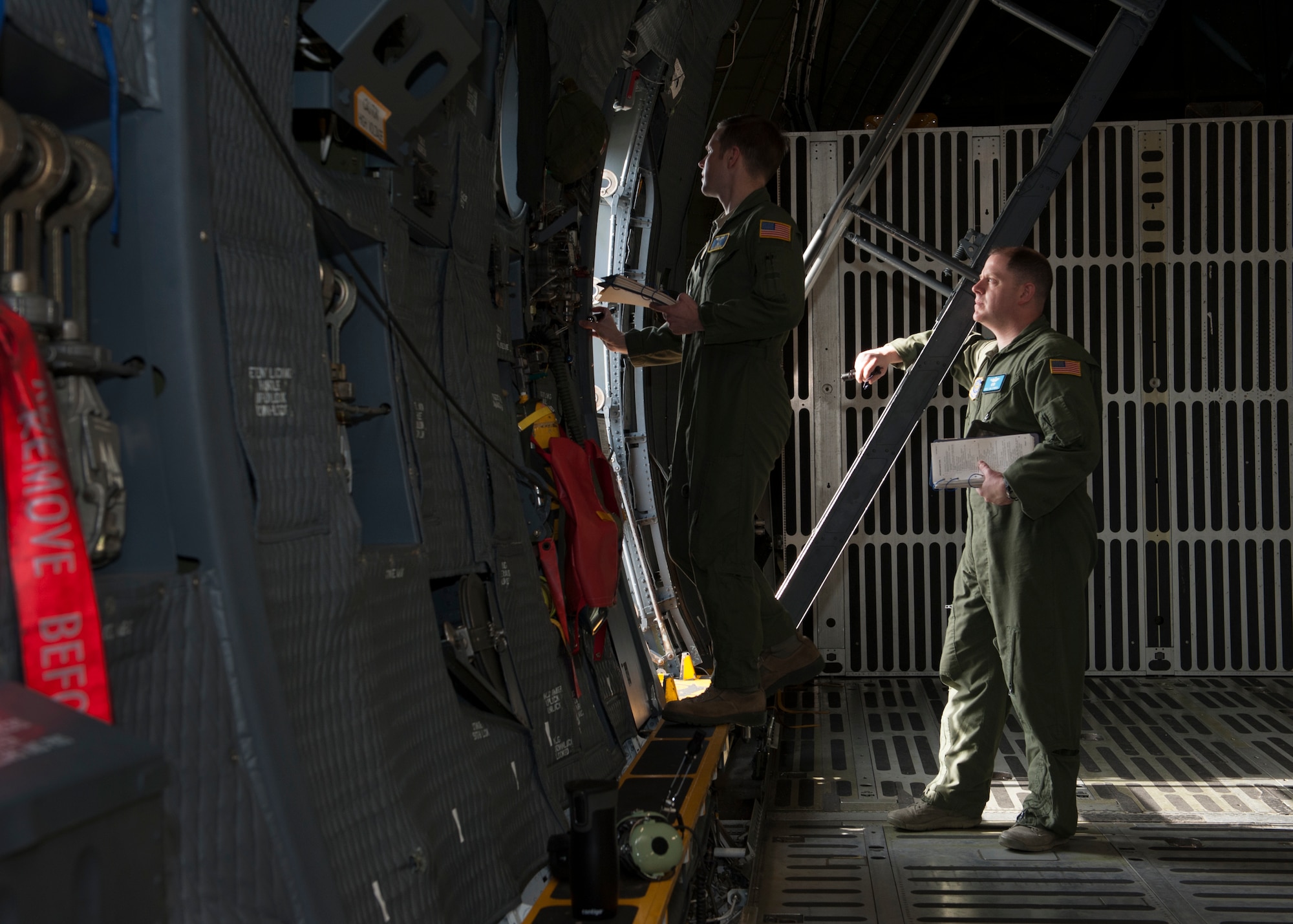 Tech. Sgt. Ryan Berry, 312th Airlift Squadron flight engineer, left, and Master Sgt. James Spinner, 9th AS flight engineer, go through pre-flight procedures during initial qualification training inside a C-5M Super Galaxy March 10, 2016, at Dover Air Force Base, Del. Flight engineer students go through hours of ground training prior to going on a local flying training mission. (U.S. Air Force photo/Senior Airman Zachary Cacicia)