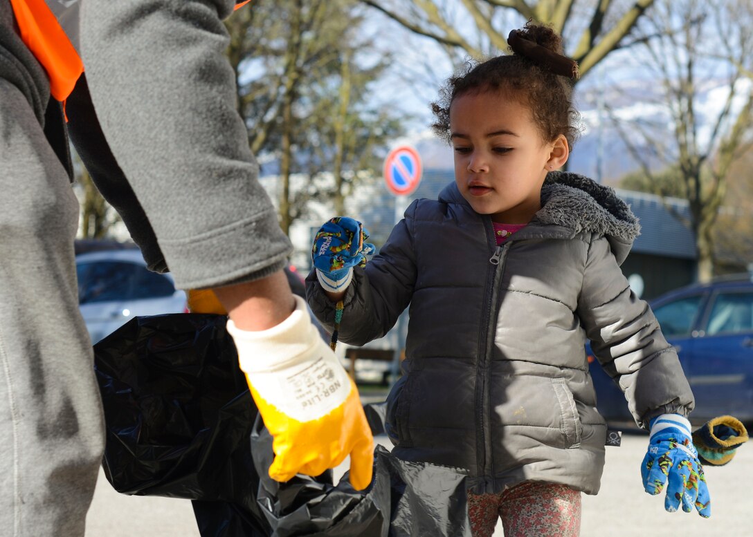 Ivy Duesbury throws away trash during a city-wide trash cleanup, March 13, 2016, in Aviano, Italy. Local and base community members collected more than 3,300 pounds of trash from approximately 37 square miles of city property. (U.S. Air Force photo by Senior Airman Austin Harvill/Released)