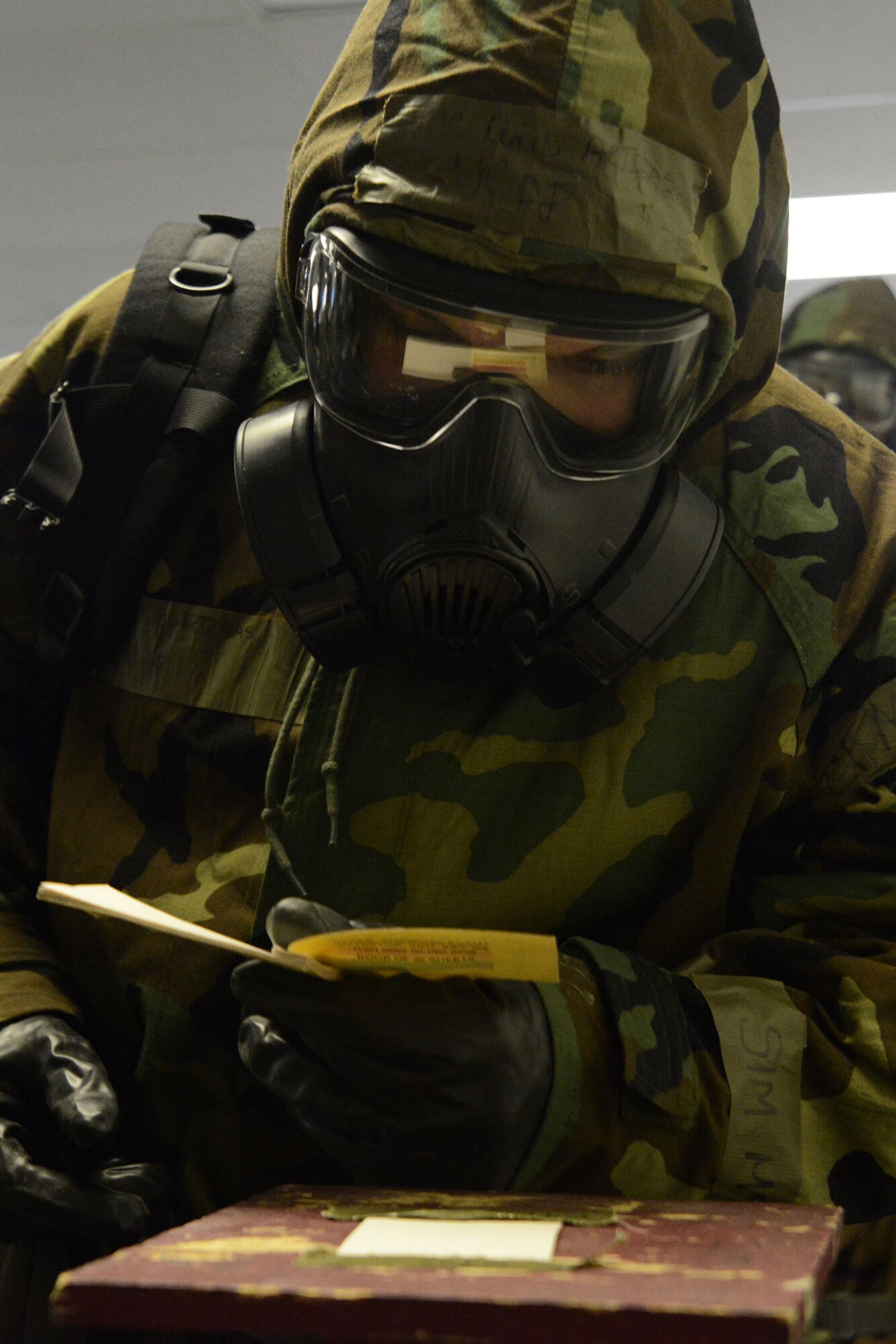 An Airman evaluates M8 chemical detection paper for contamination in a chemical, biological, radiological and nuclear training class at Joint Base Elmendorf-Richardson, Alaska, Feb. 9, 2016. Students are evaluated on how effective they execute pre- and post-attack actions during the weekly CBRN training class. (U.S. Air Force photo by Airman 1st Class Christopher R. Morales)