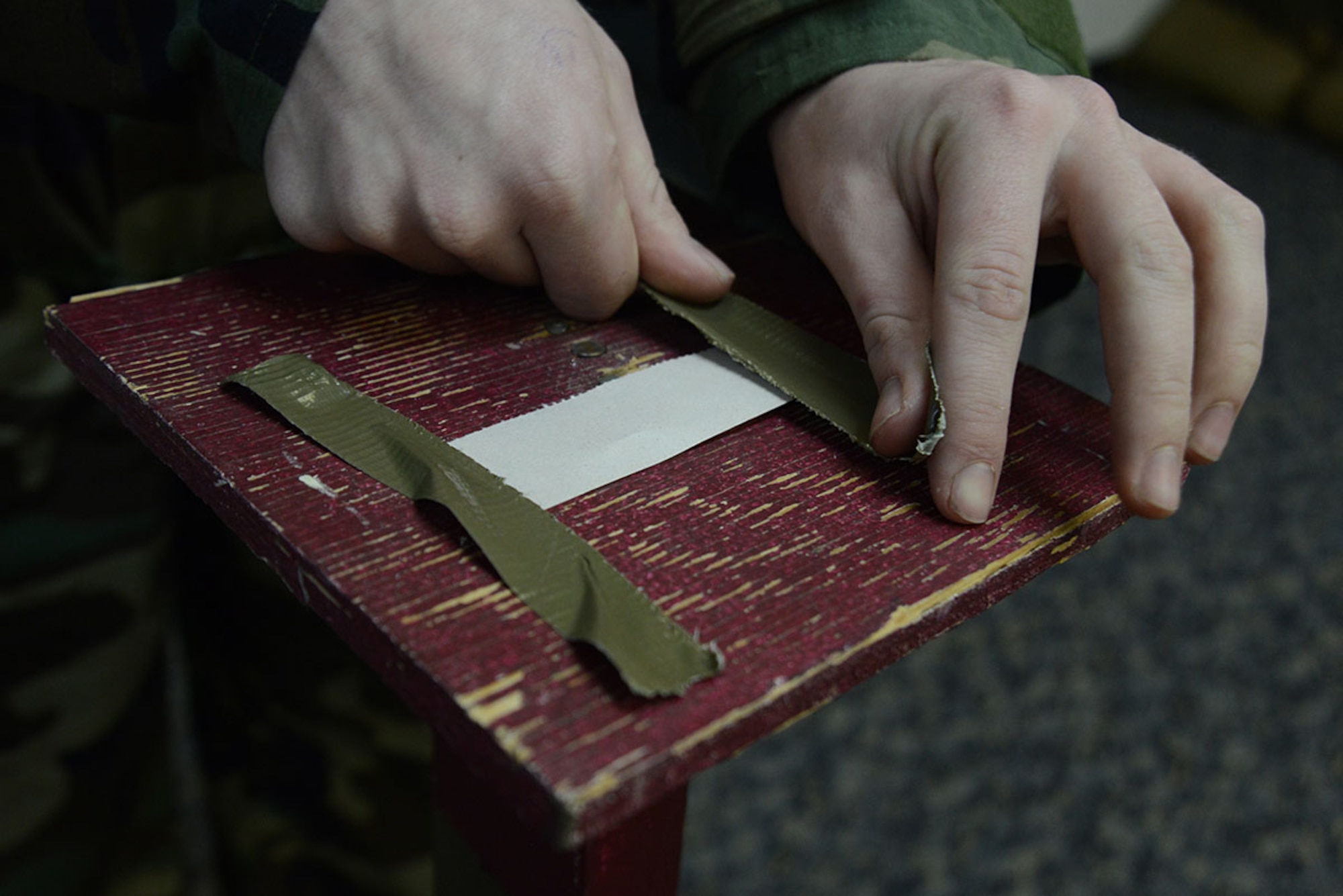 An Airman tapes M8 chemical detection paper for training at Joint Base Elmendorf-Richardson, Alaska, Feb. 9, 2016. Students are evaluated on how effectively they execute pre- and post-attack actions during the weekly chemical, biological, radiological and nuclear training class. (U.S. Air Force photo by Airman 1st Class Christopher R. Morales)