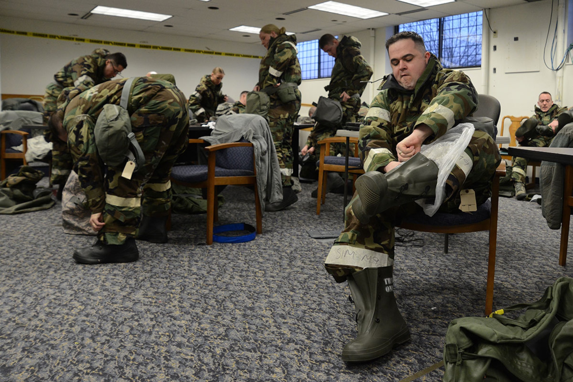 Students don their Mission Oriented Protective Posture level two gear in a timed evaluation at Joint Base Elmendorf-Richardson, Alaska, Feb. 9, 2016. Students are evaluated on how quickly they don their MOPP level two equipment then how effectively they don their M50 mask during the weekly chemical, biological, radiological and nuclear training class. (U.S. Air Force photo by Airman 1st Class Christopher R. Morales)