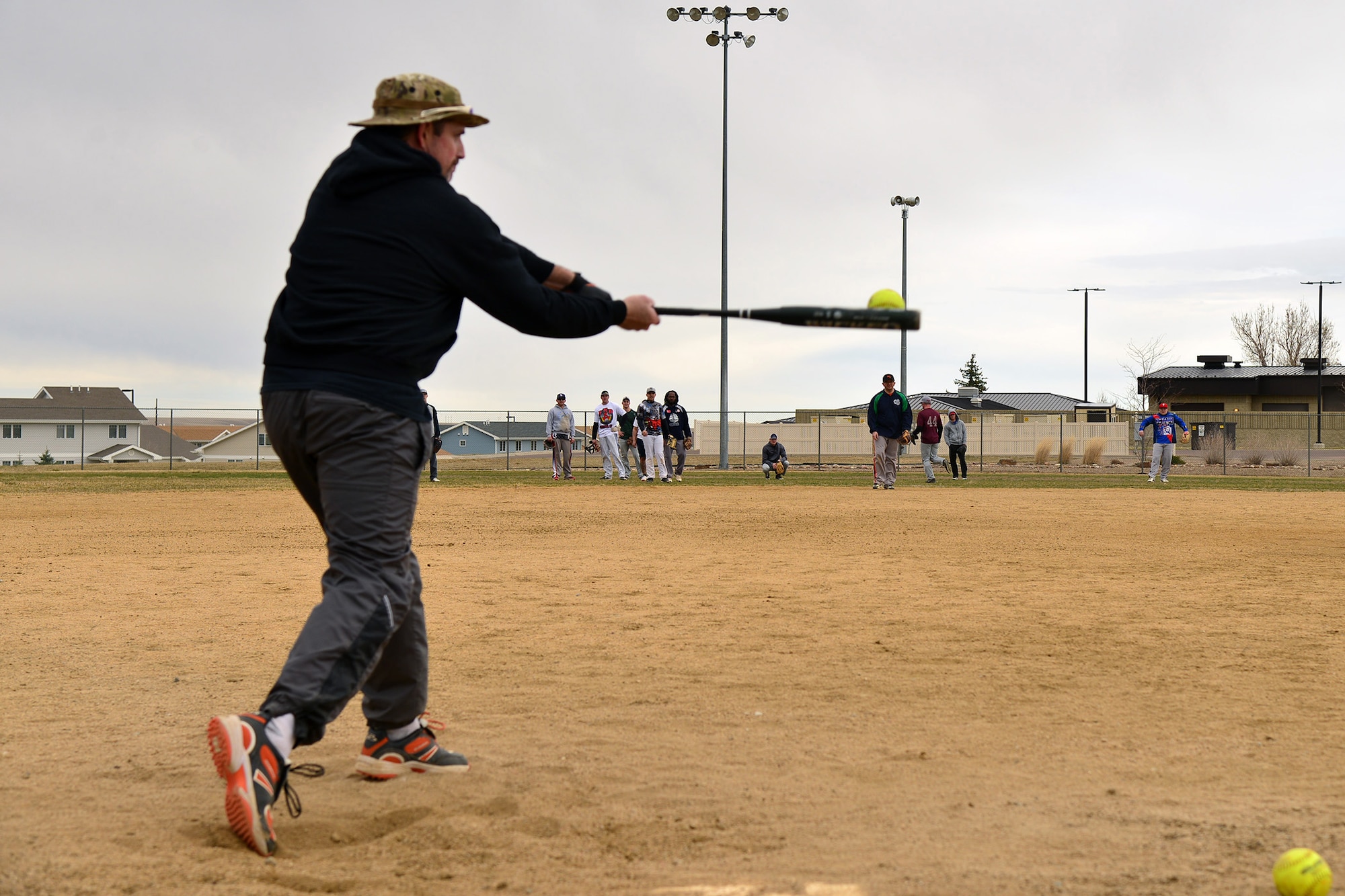 An Airman hits balls to individuals at softball team tryouts March 12, 2016, at Malmstrom Air Force Base, Mont. Members selected for the team will travel to military softball tournaments across the U.S. to represent the 341st Missile Wing. (U.S. Air Force photo/Airman Daniel Brosam)