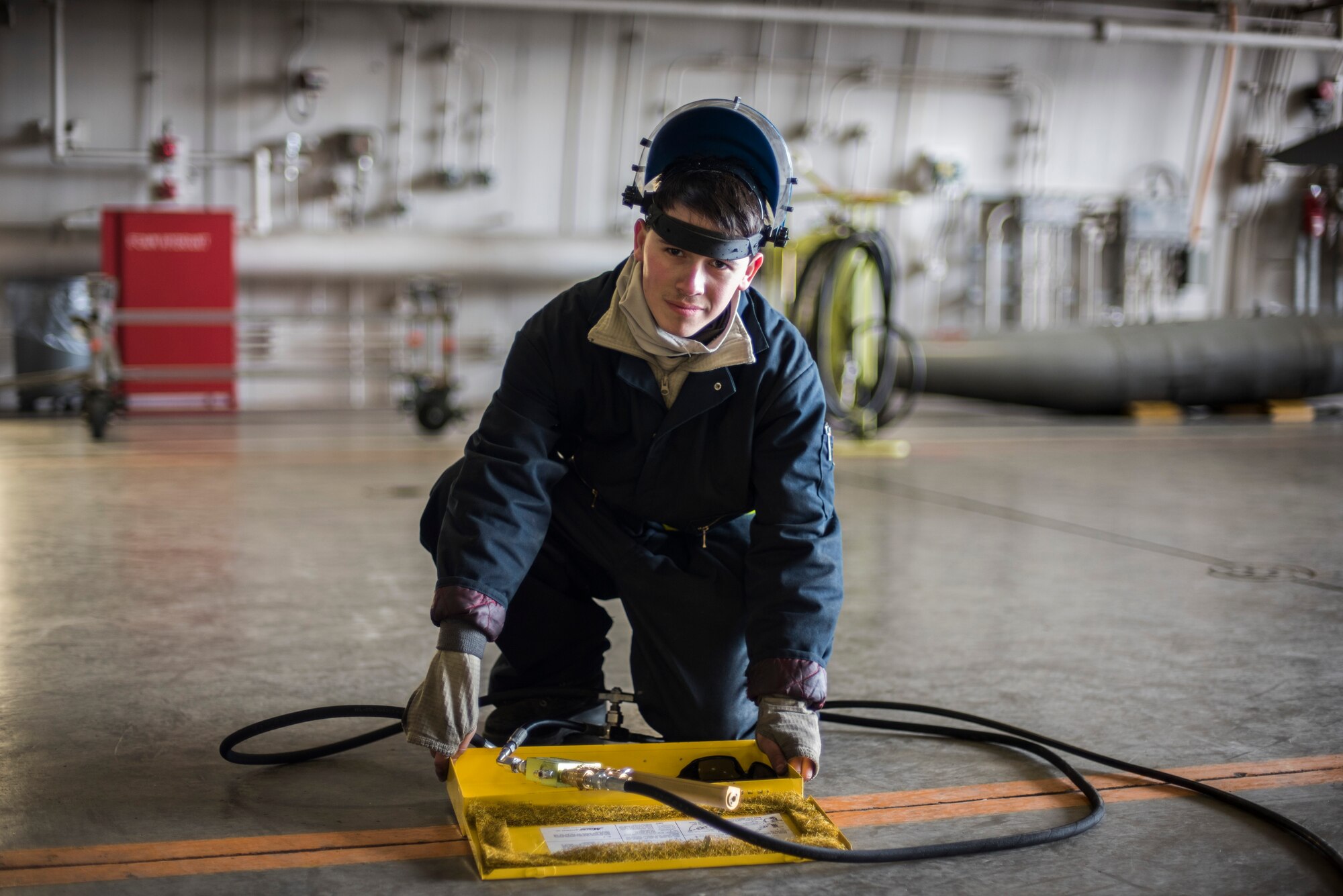 U.S. Air Force Senior Airman Bradley Poirier, a crew chief with the 14th Aircraft Maintenance Squadron, looks at the camera for a photo at Misawa Air Base, Japan, March 15, 2016. Poirier’s job as a crew chief is to ensure the F-16 is capable of flying along with ensuring the safety of pilots and maintainers. (U.S. Air Force photo by Senior Airman Brittany A. Chase)